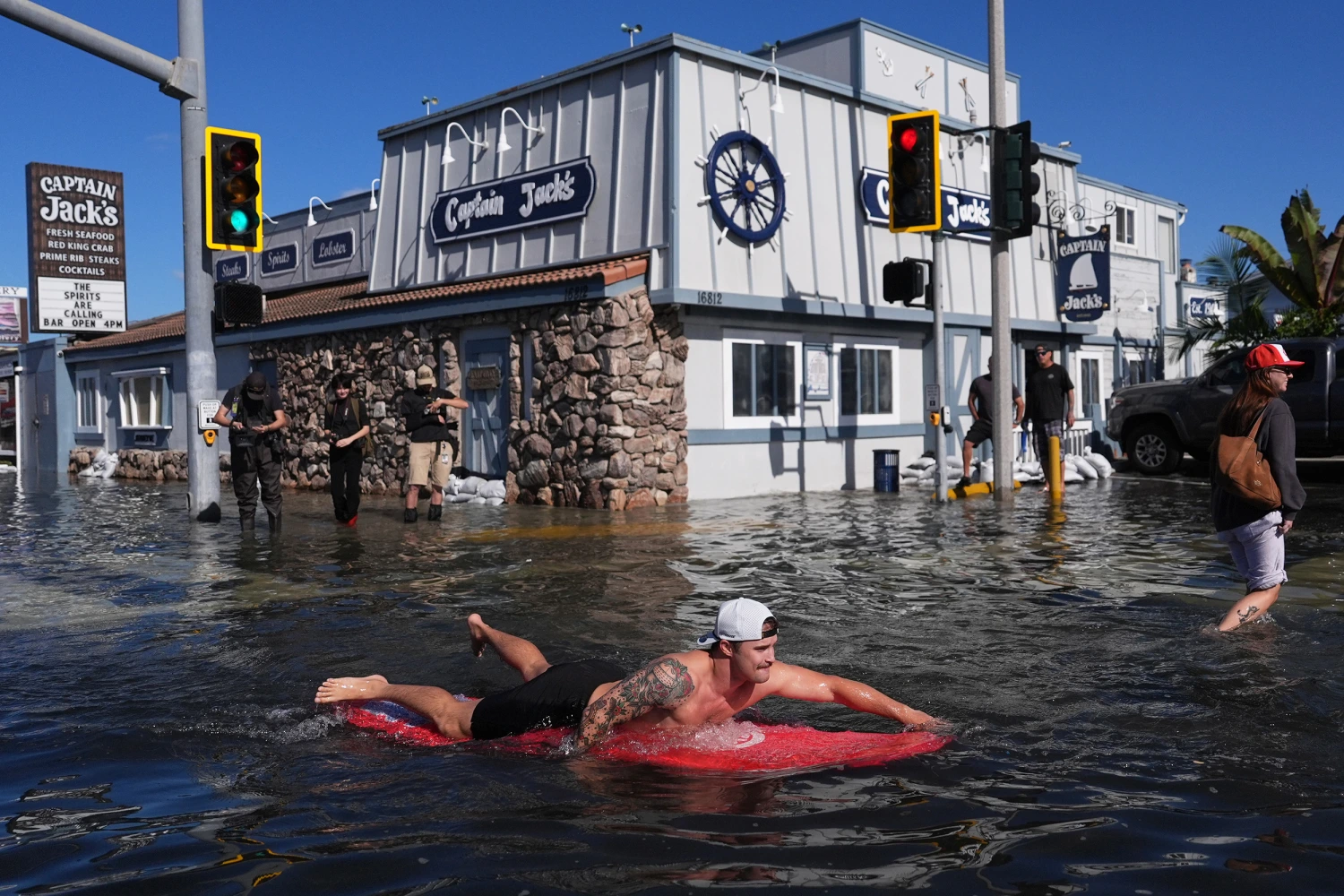 A man surfs through floodwaters in Huntington Beach, Calif., Wednesday, Oct. 28, 2026.