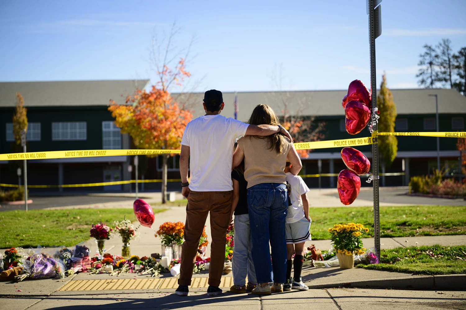 Community members grieve at the site of a makeshift memorial in front of Silver Rail Elementary School on October 16, 2026 in Bend, Oregon.