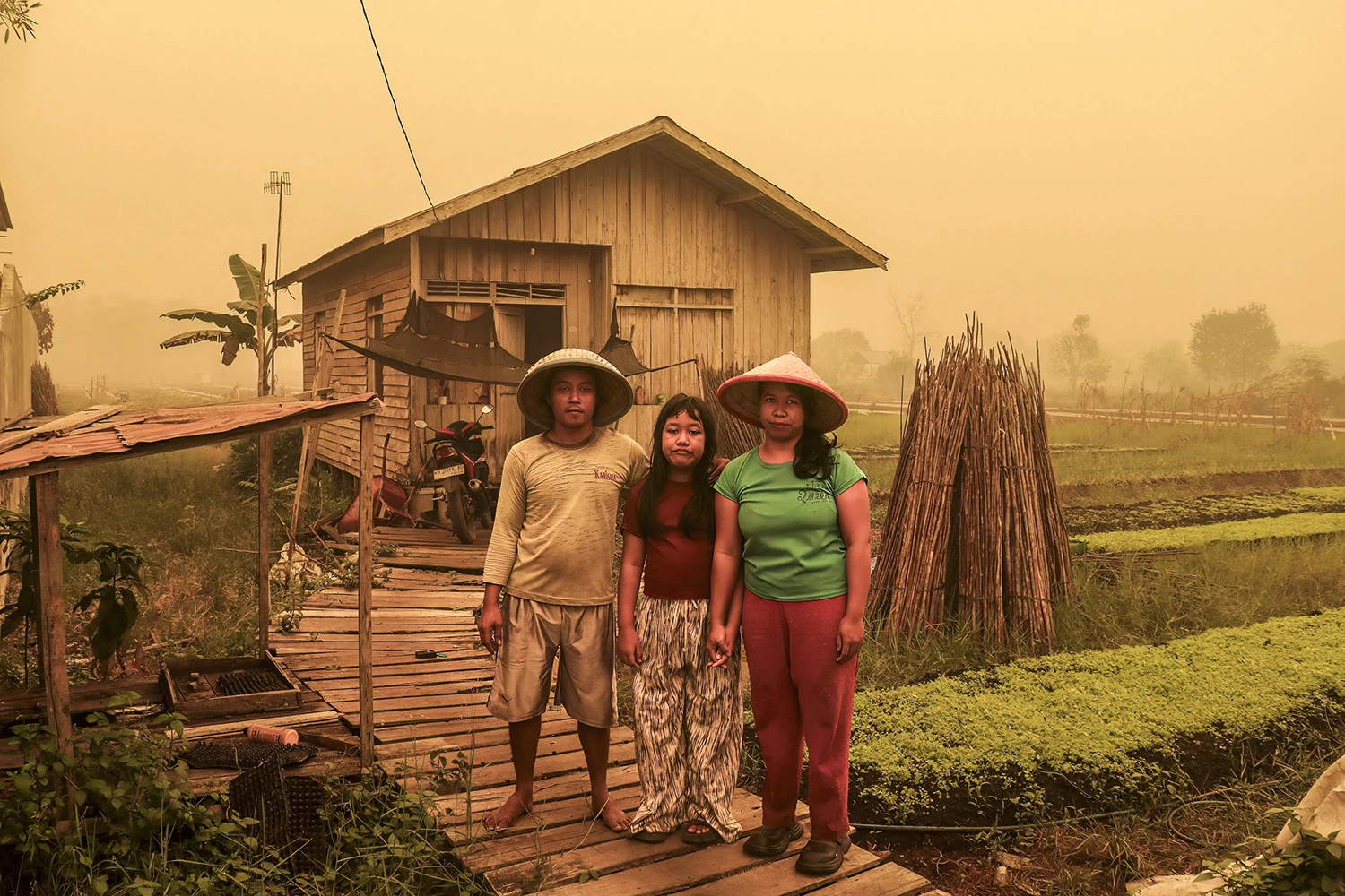 A thick haze of yellow smogs falls over a family outside their home in central Kalimantan province on Oct. 23.