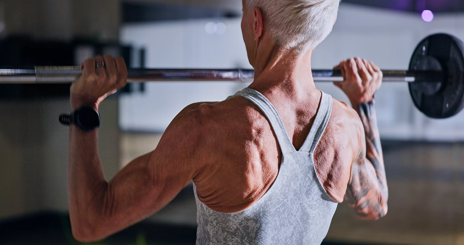 Fitness, bodybuilder and sports white woman weightlifting in a gym for a strong body. Exercise, health and training with a female athlete concentrating while lifting weights for a workout
