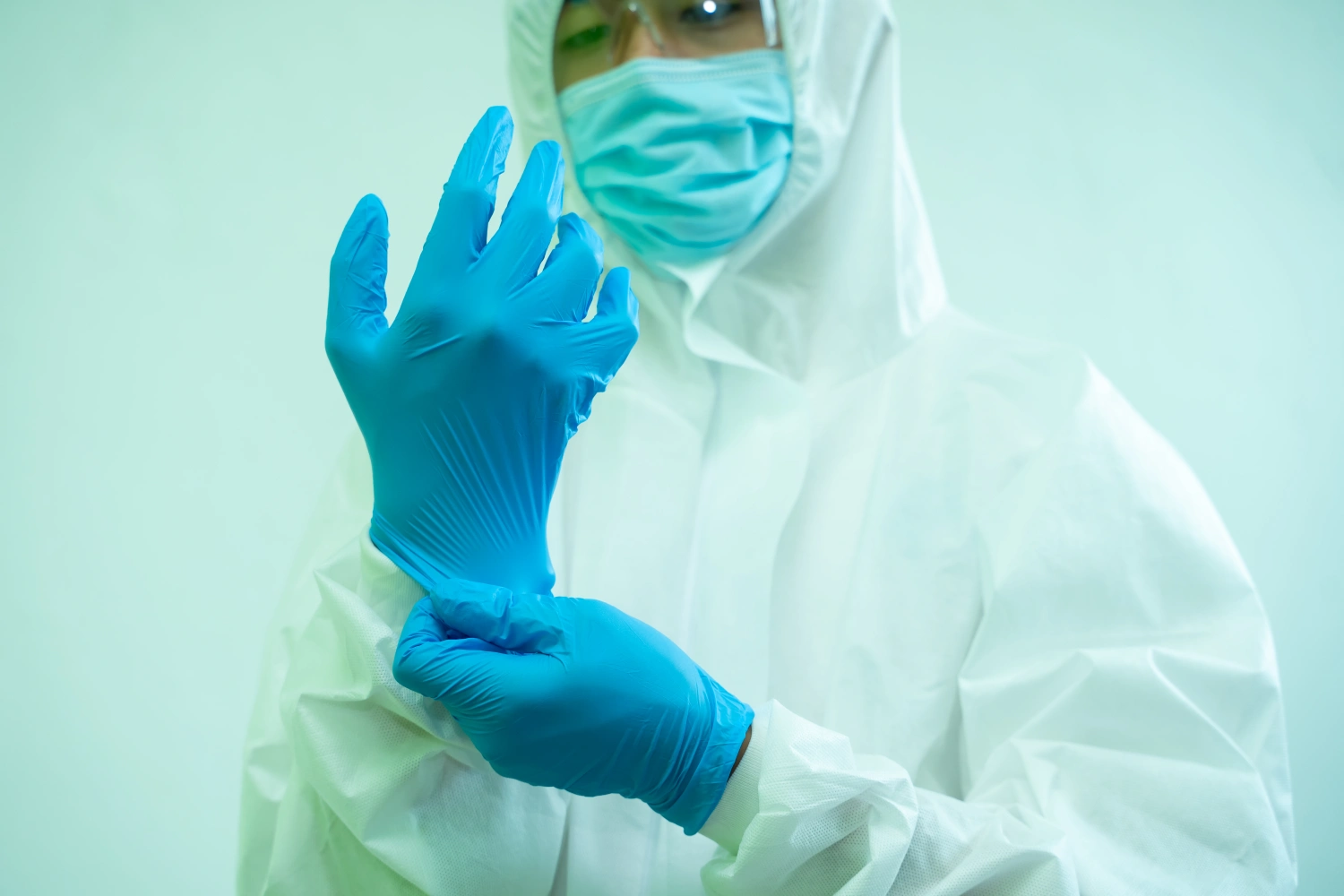 Doctor in hazmat PPE protective clothing wear medical rubber gloves,Concept of corona virus treatment.