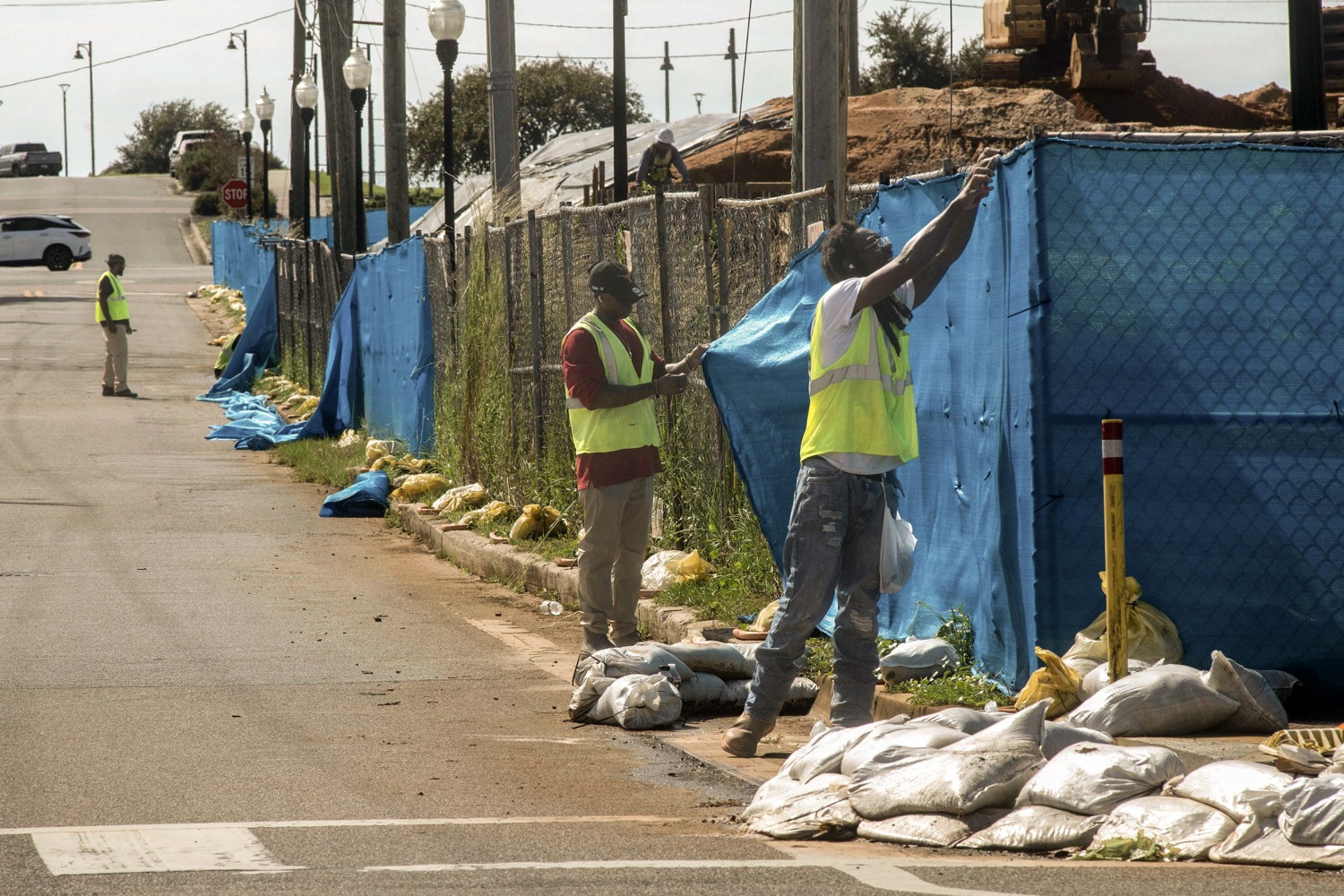 Workers remove wind screens from the construction site in Pensacola, Fla., as as the Gulf Coast area prepares for Tropical Storm Isaias on Oct. 7, 2026.
