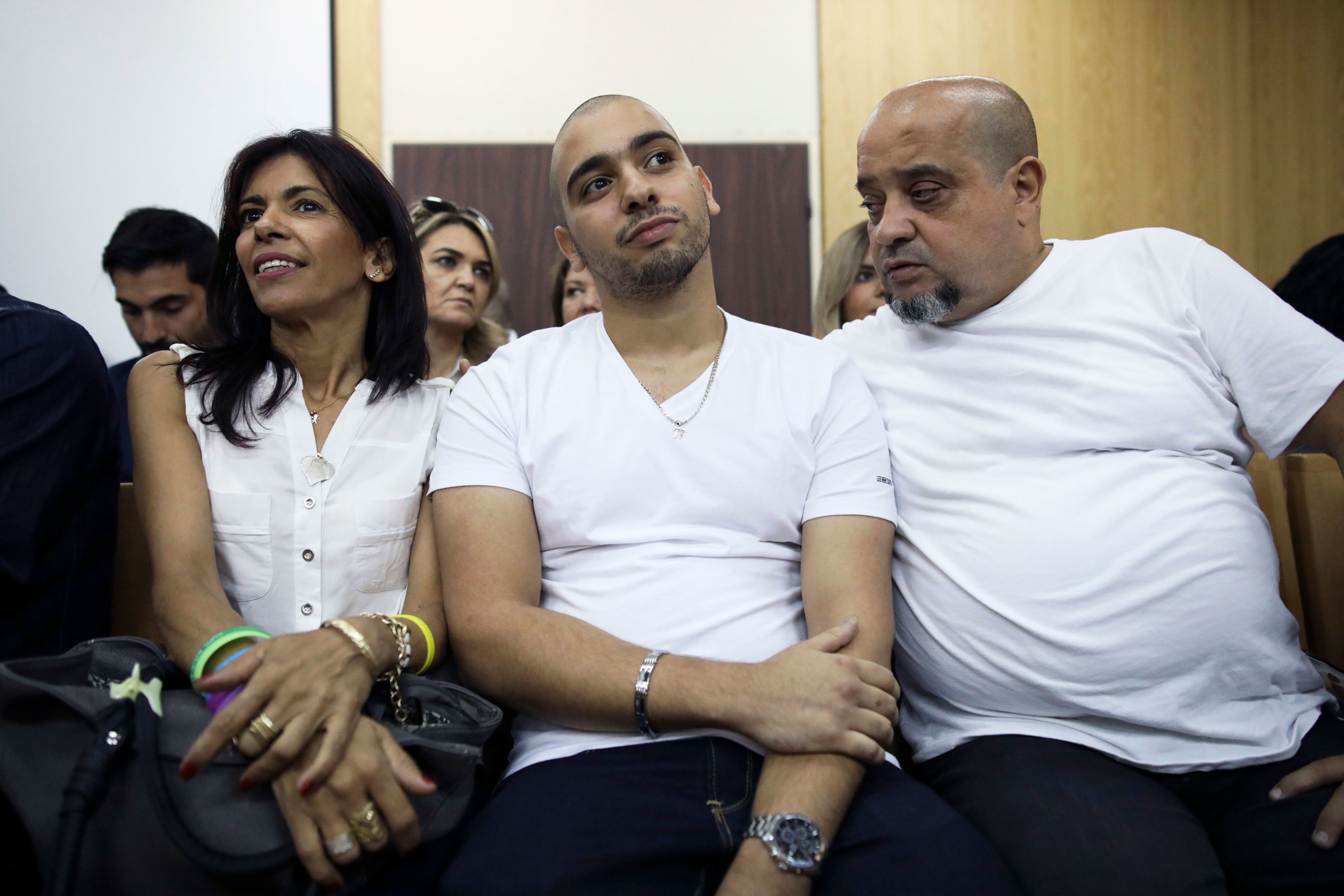 In this 2017 photo, Elor Azaria, flanked by his parents, sits inside a Israeli military court in Tel Aviv.