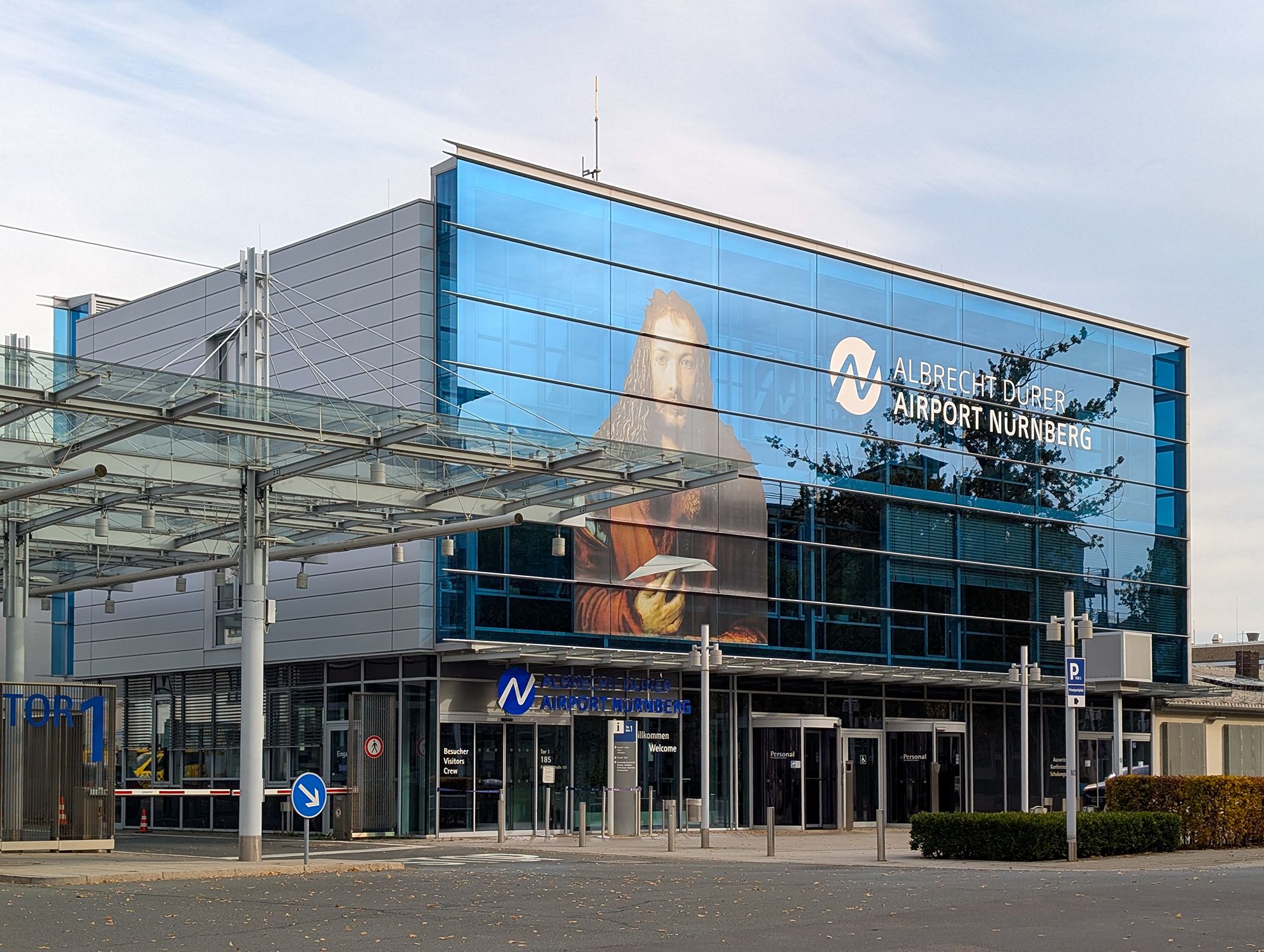 The glass facade at Albrecht Duerer Airport in Nuremberg, Germany, on October 19, 2025, features a large depiction of Albrecht Duerer's self-portrait holding a paper airplane.