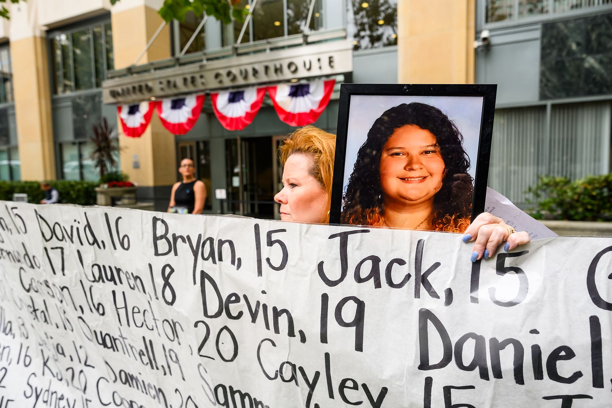 Erin Popolo holds a picture of daughter Emily Murilla, who died at age 17, during a protest against social media platforms outside of the federal courthouse in Oakland, California where the Meta trial was underway on Tuesday, Aug. 18, 2026.