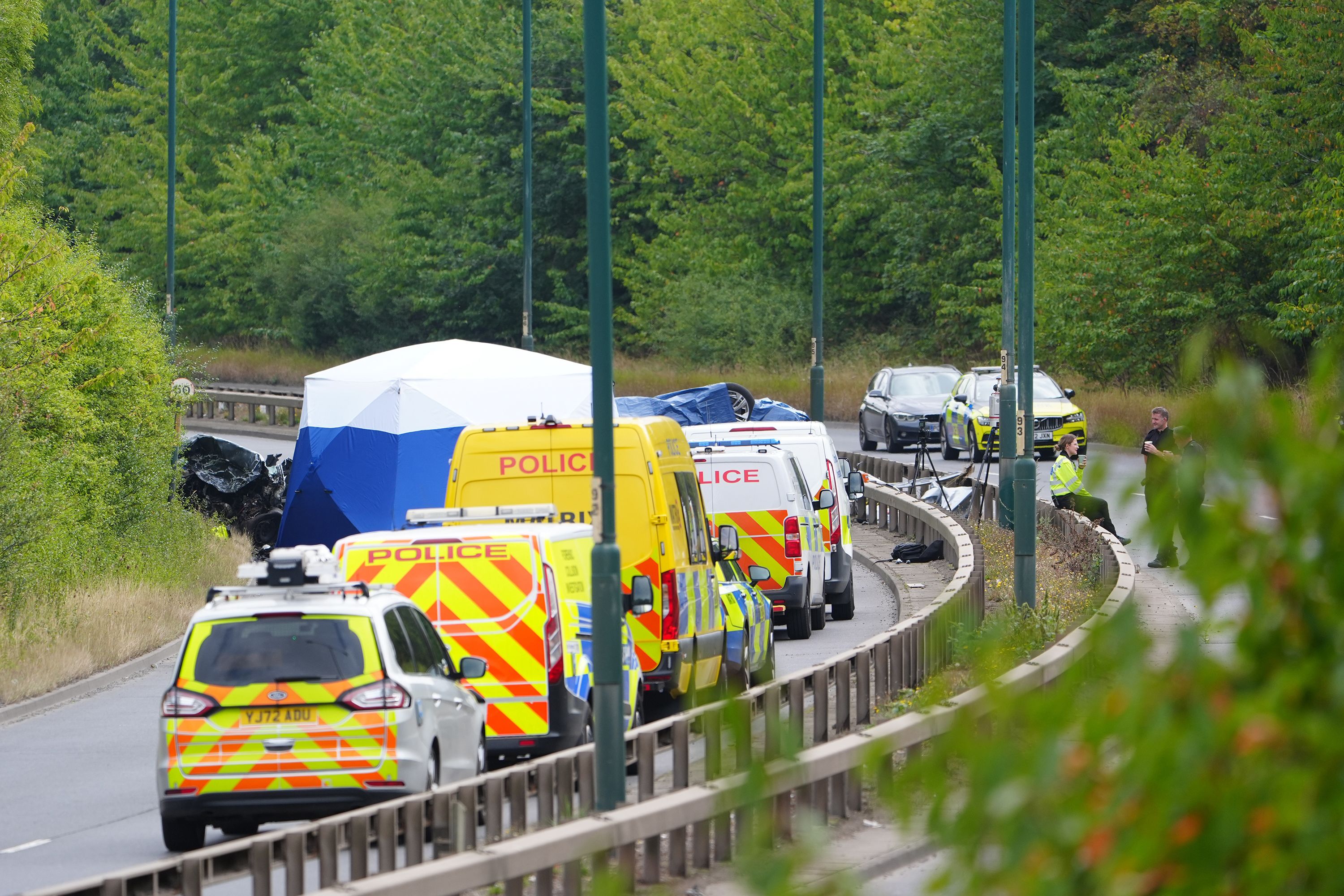 Police officers at the scene of a fatal crash involving a police car and a Volkswagen Passat on the A66 in South Bank, near Middlesbrough, England, on Saturday.