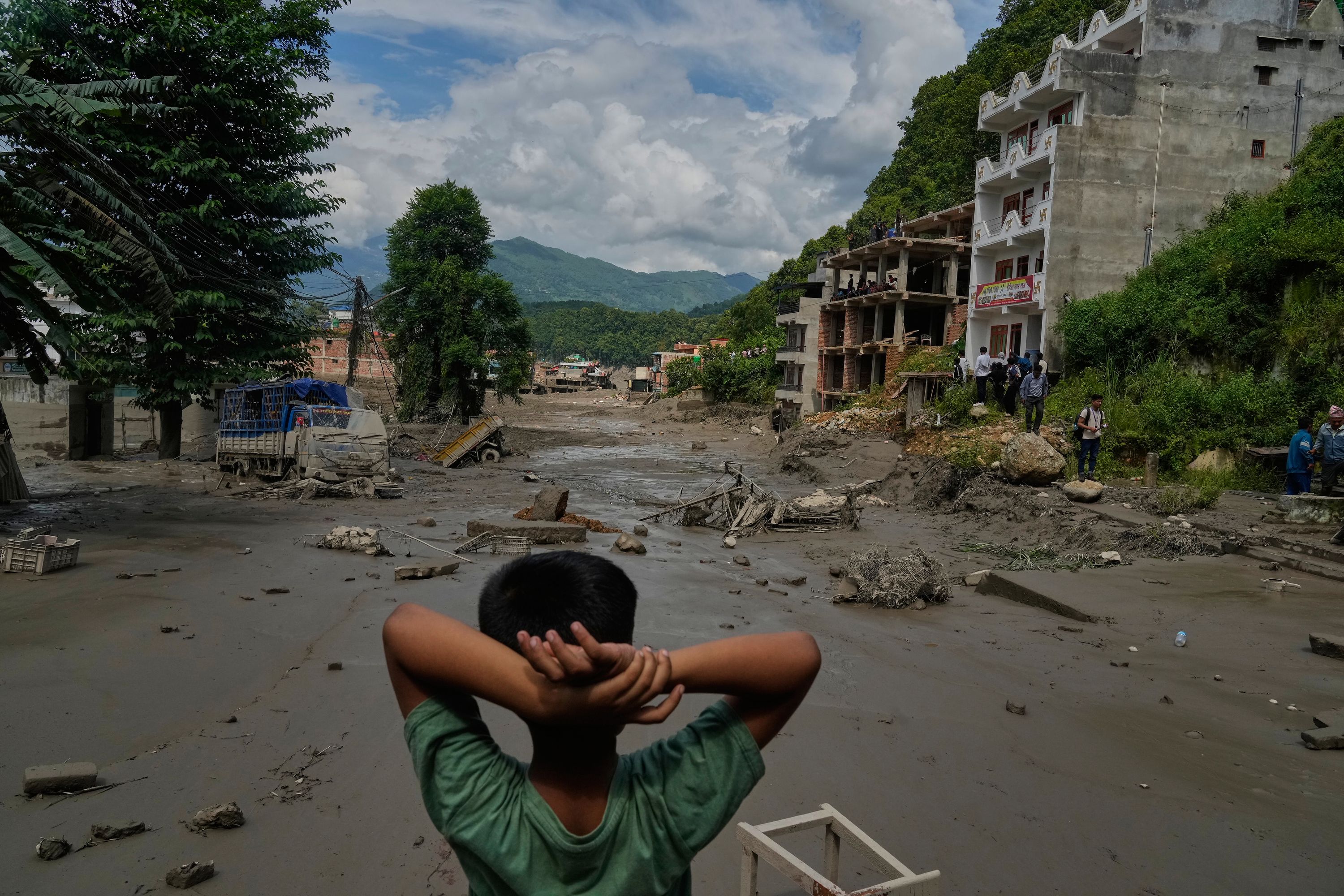 A boy looks at the devastation caused by flash flooding along the Trishuli River in Nepal's Nuwakot district, Wednesday, Aug. 26, 2026. (AP Photo/Niranjan Shrestha)