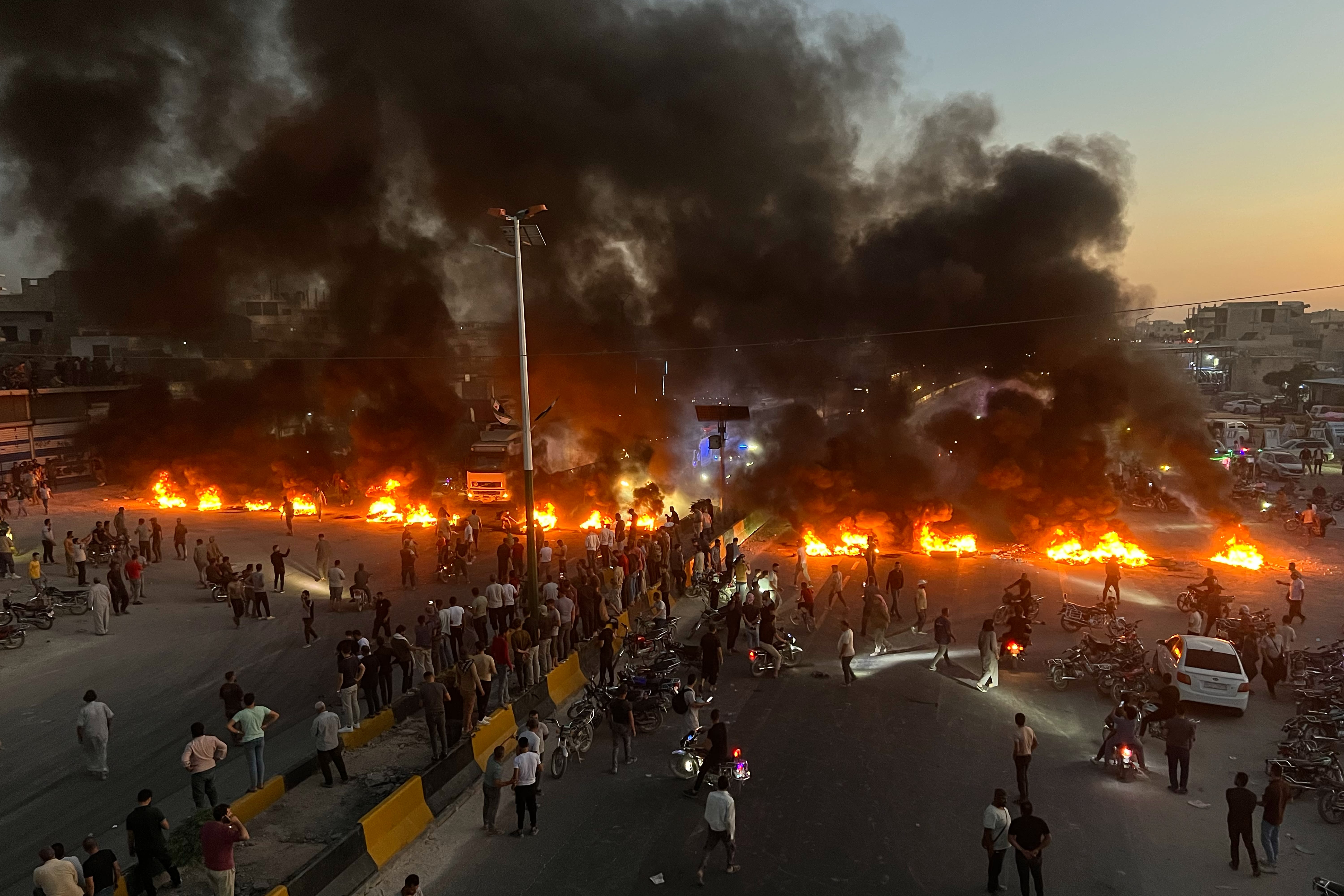 Protesters burn tires and other debris to block a highway as demonstrations over fuel price increases spread across Syria, in Maarat al-Numan, Idlib province, Sunday, September 13.