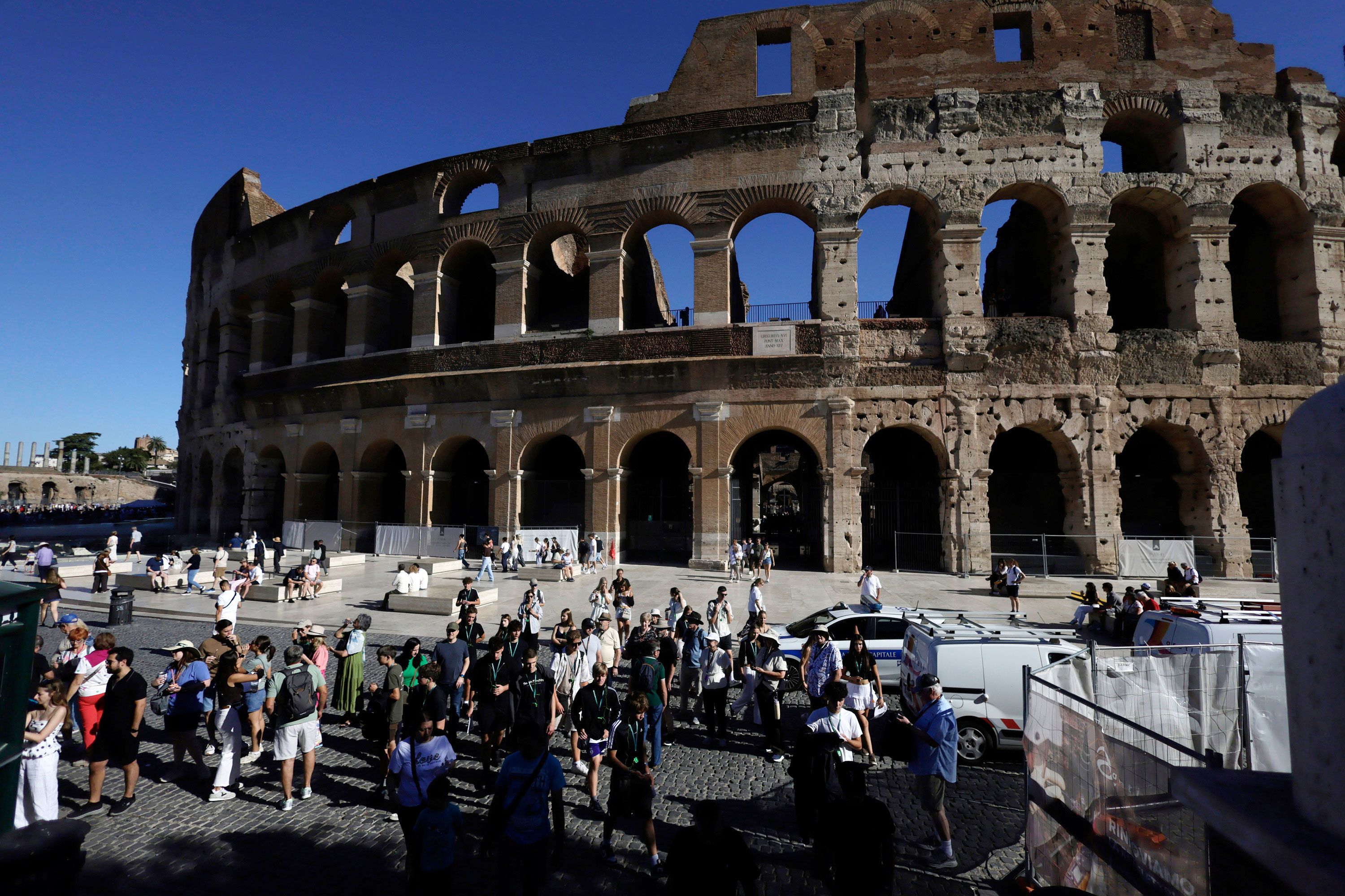 Tourists gather outside the Colosseum, closed to the public for the day to mourn a worker who fell to his death late Tuesday when installing cabling inside the ancient amphitheater in Rome, Wednesday, September 23.
