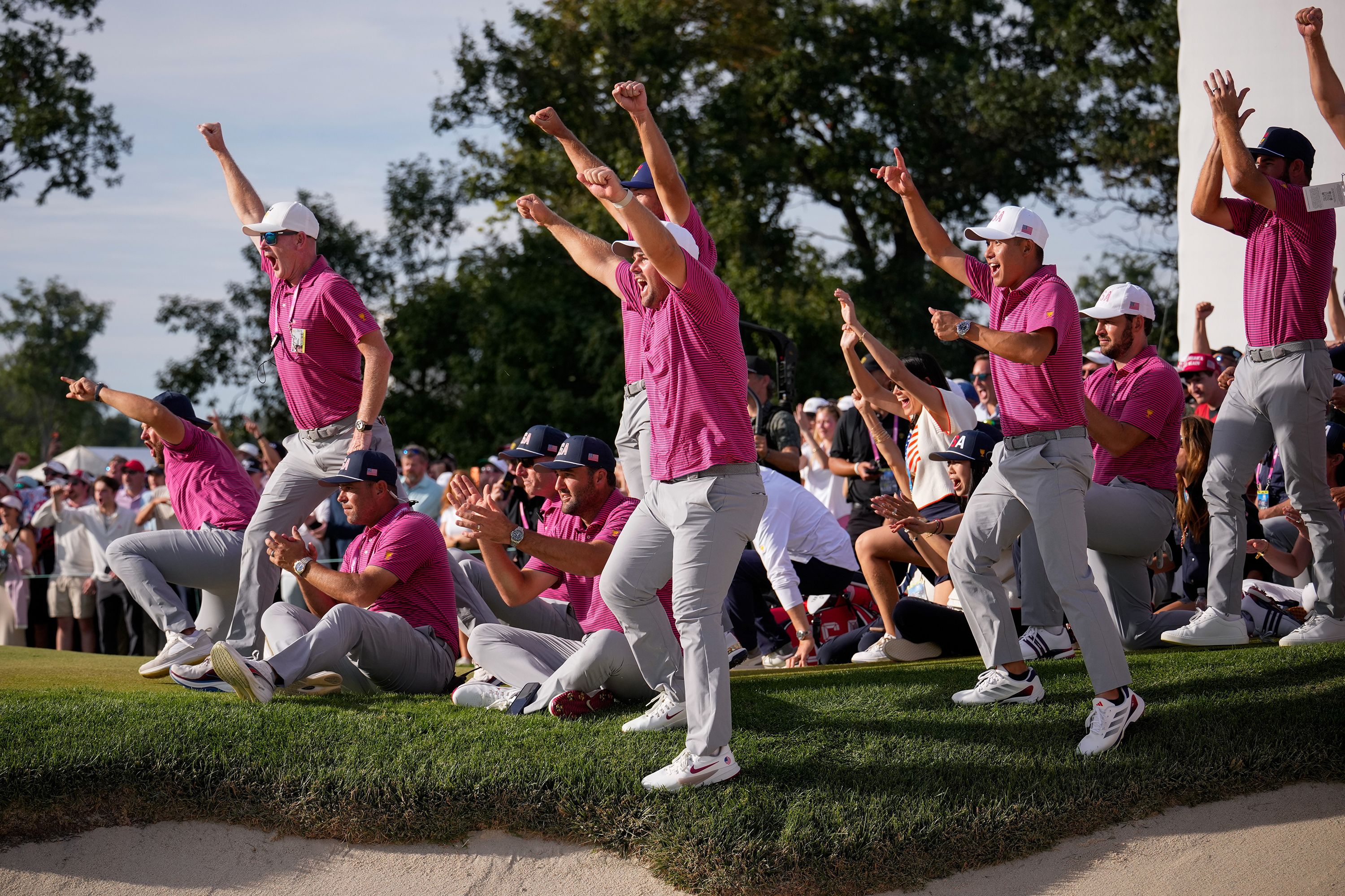 Members of the USA team celebrate Jackson Koivun's win on the 18th green against the International team during a Presidents Cup golf tournament final round singles match at Medinah Country Club, Illinois, on Sunday, Sept. 27.