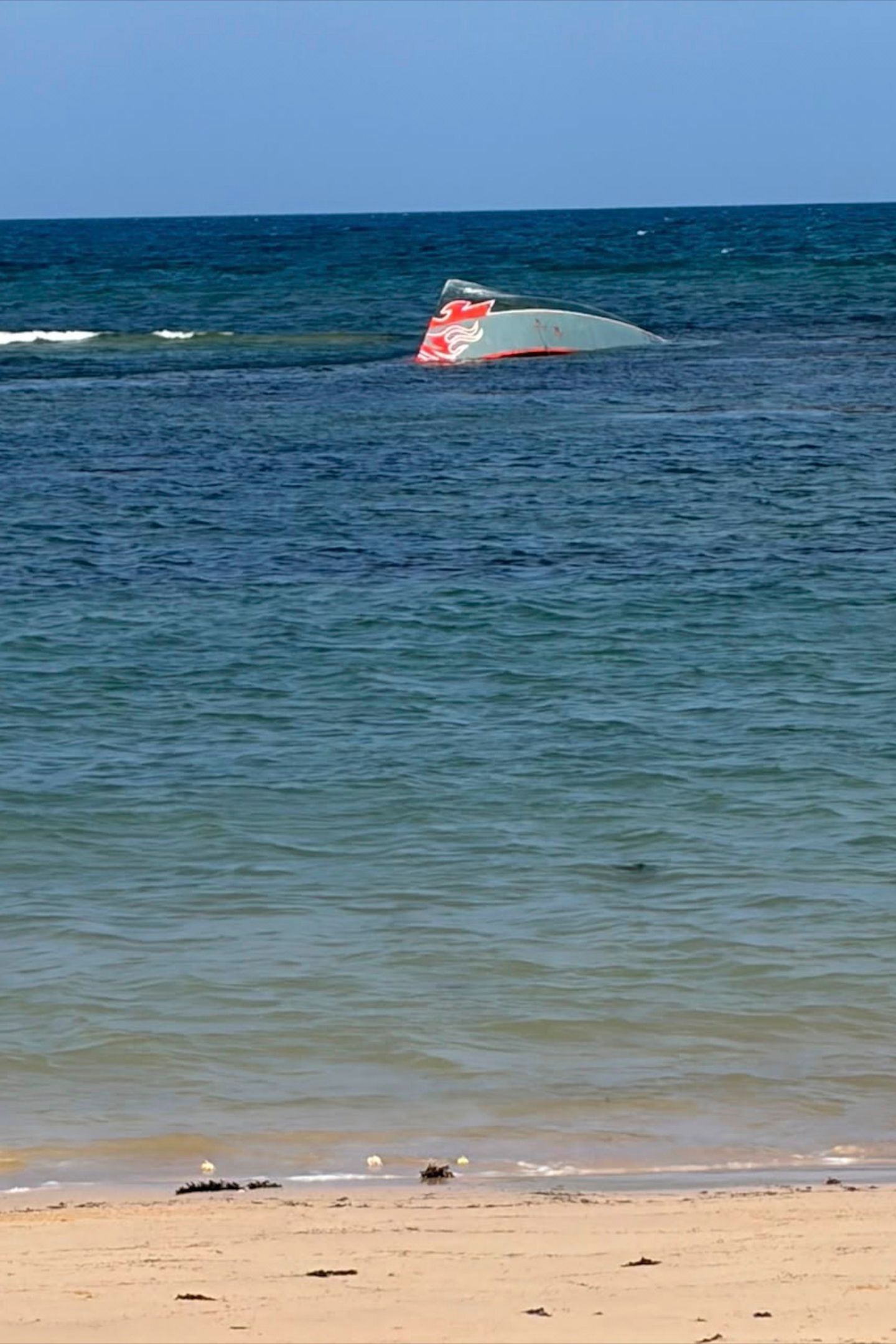 A migrant vessel lies partially submerged after it capsized near Guhere, north of Obock, Djibouti, while carrying 305 passengers, on Saturday, Oct. 10.