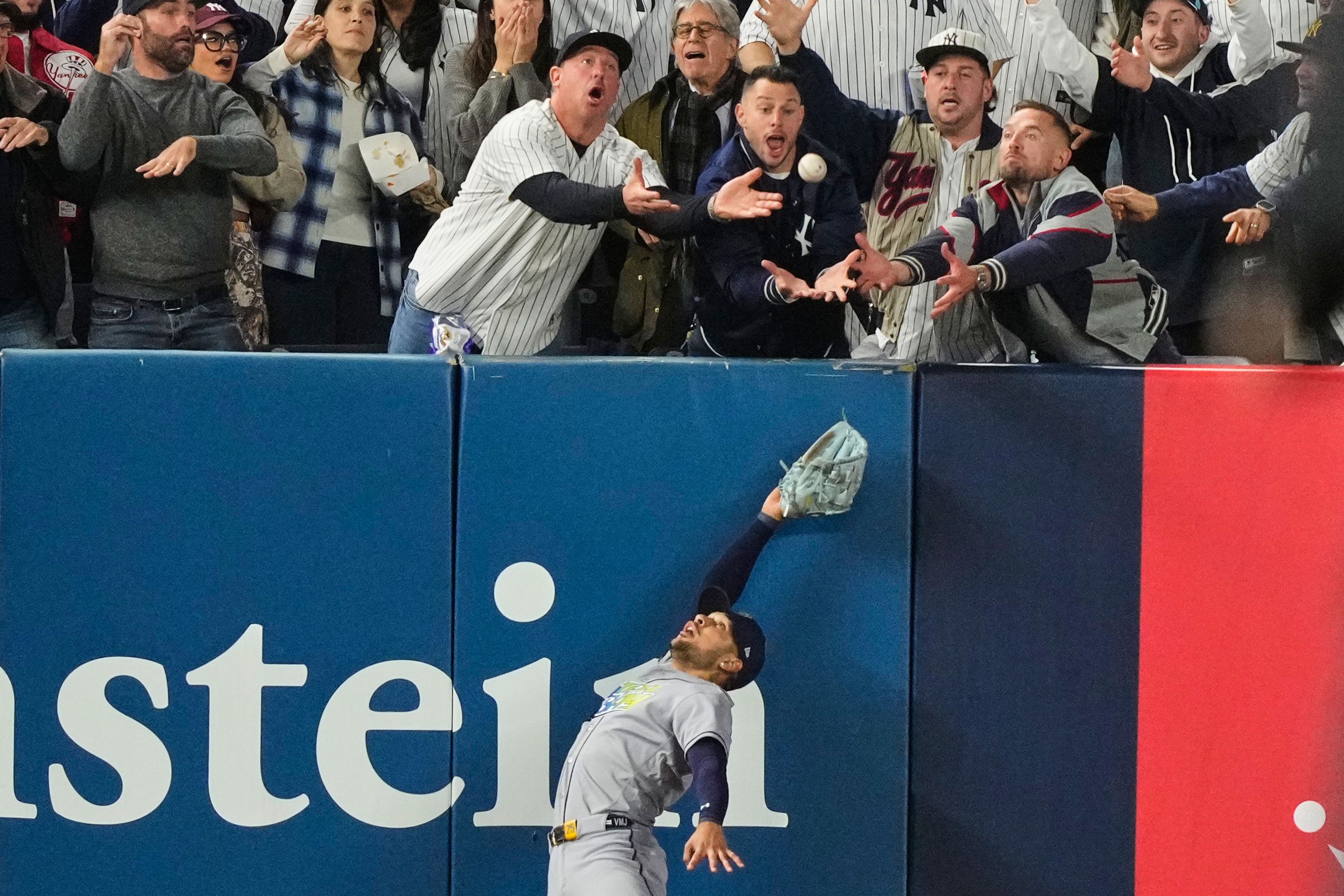 Tampa Bay Rays left fielder Victor Mesa Jr. makes an attempt on a ball interfered with by fans that umpires reviewed and ruled a run-scoring double by New York Yankees' Anthony Volpe.