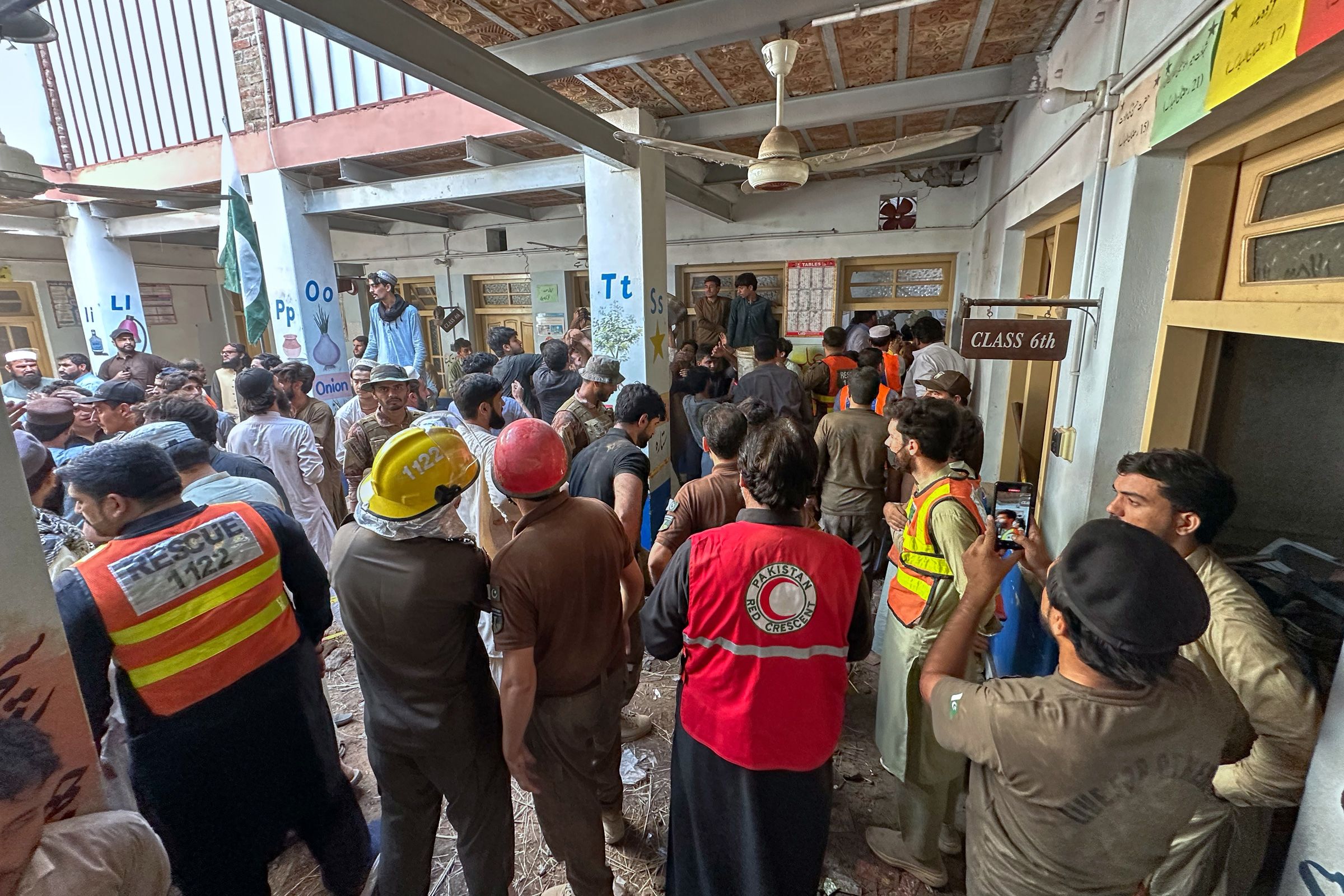 Rescue workers and volunteers take part in the rescue operation at the site of a roof collapse at a private school, in Peshawar, Pakistan, on Thursday.