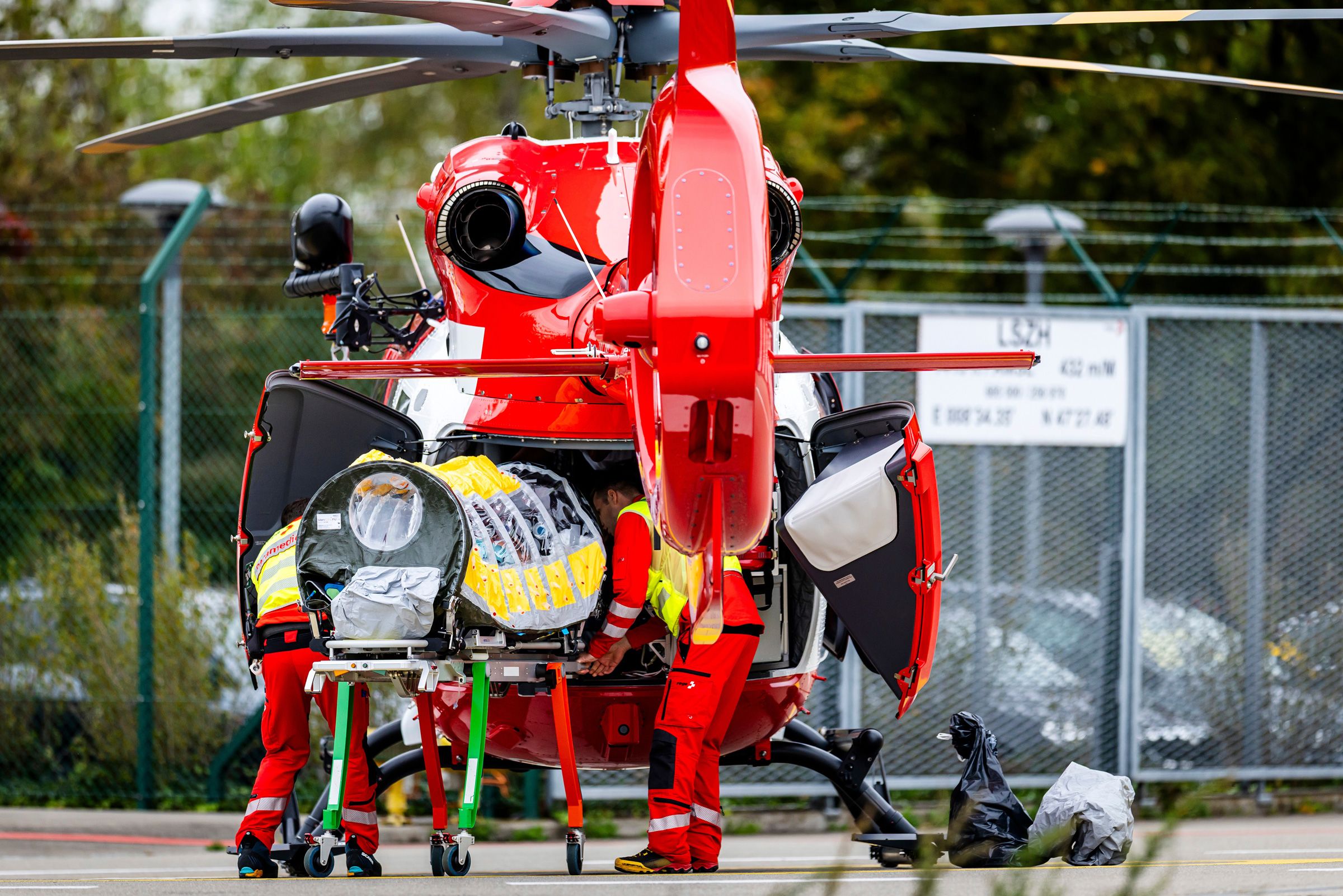 A patient is transferred in a isolation unit from a rescue aircraft to a helicopter of Swiss Air Rescue at Zurich Airport on Monday, in Zurich, Switzerland.