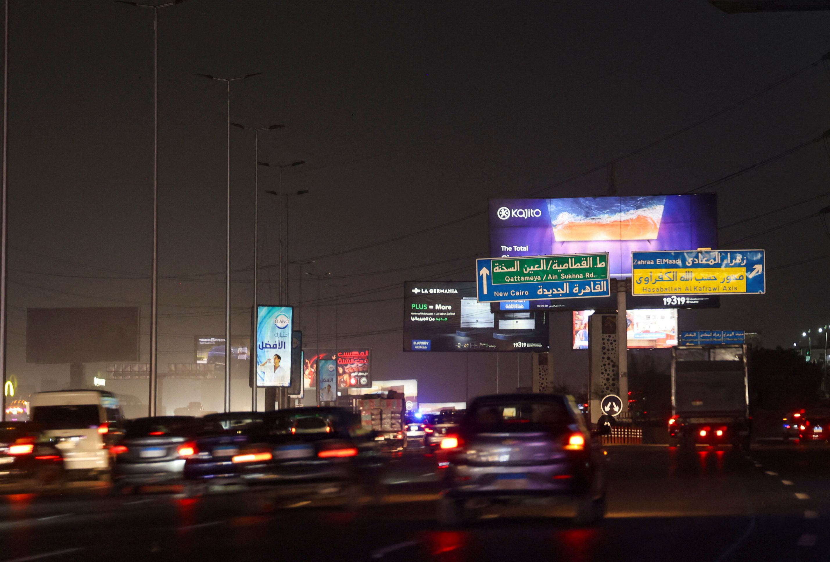 Vehicles drive past brightly lit billboards in Cairo, Egypt, September 16, 2025.