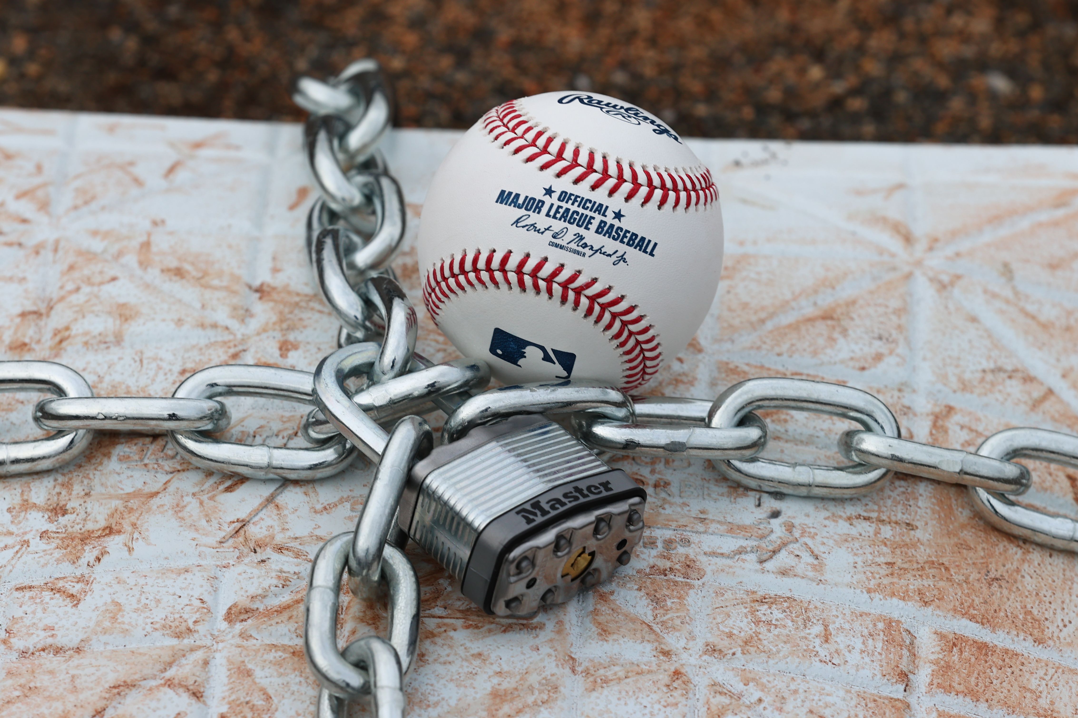 LINCROFT, NJ - JANUARY 28:  An official MLB baseball sits on top of an MLB game-used base with a lock and chain around it to represent the lockout between Major League Baseball (MLB) and the Major League Baseball Players Association (MLBPA) on January 28, 2022  in Lincroft, New Jersey.  (Photo by Rich Graessle/Icon Sportswire via Getty Images)