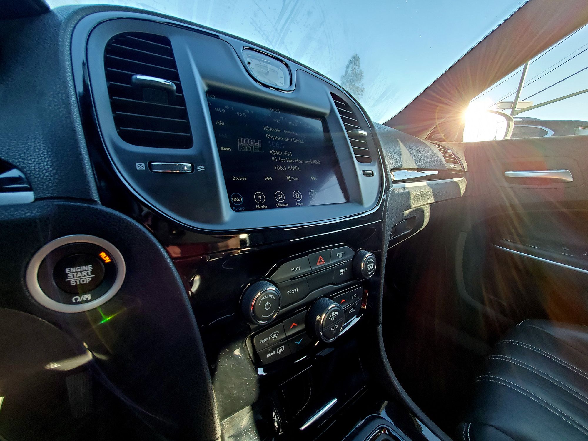 Inside view of a Chrysler automobile with sun visible featuring a digital dashboard, car radio and CD player, and AC command buttons, Walnut Creek, California, October 23, 2020.