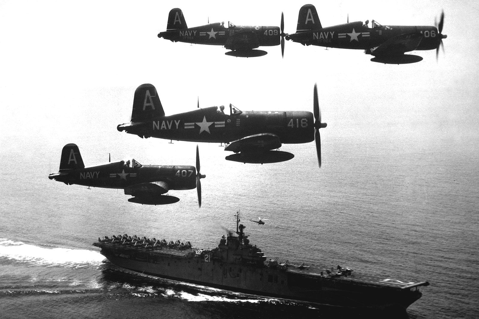 Four F4U Corsair fighter airplanes return from a combat mission over North Korea and circle the aircraft carrier USS Boxer while waiting for the planes in the next strike force to launch from the deck, September 1951.