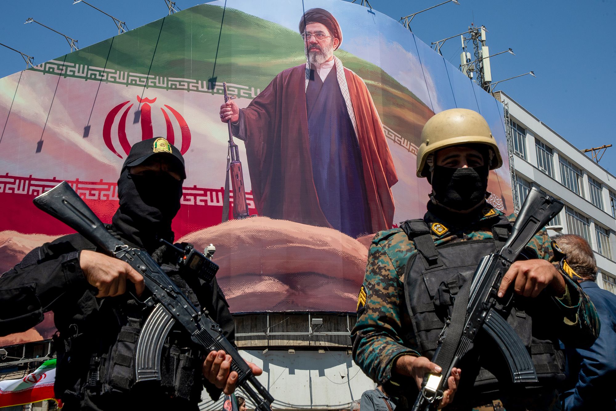 Members of the Iranian security forces stand guard under a large portrait of Iran's new Supreme Leader, Mojtaba Khamenei, during a memorial to mark the 40th day since his father, Ali Ayatollah Khamenei, was killed in US-Israeli joint strikes, on April 9, 2026 in Tehran, Iran.