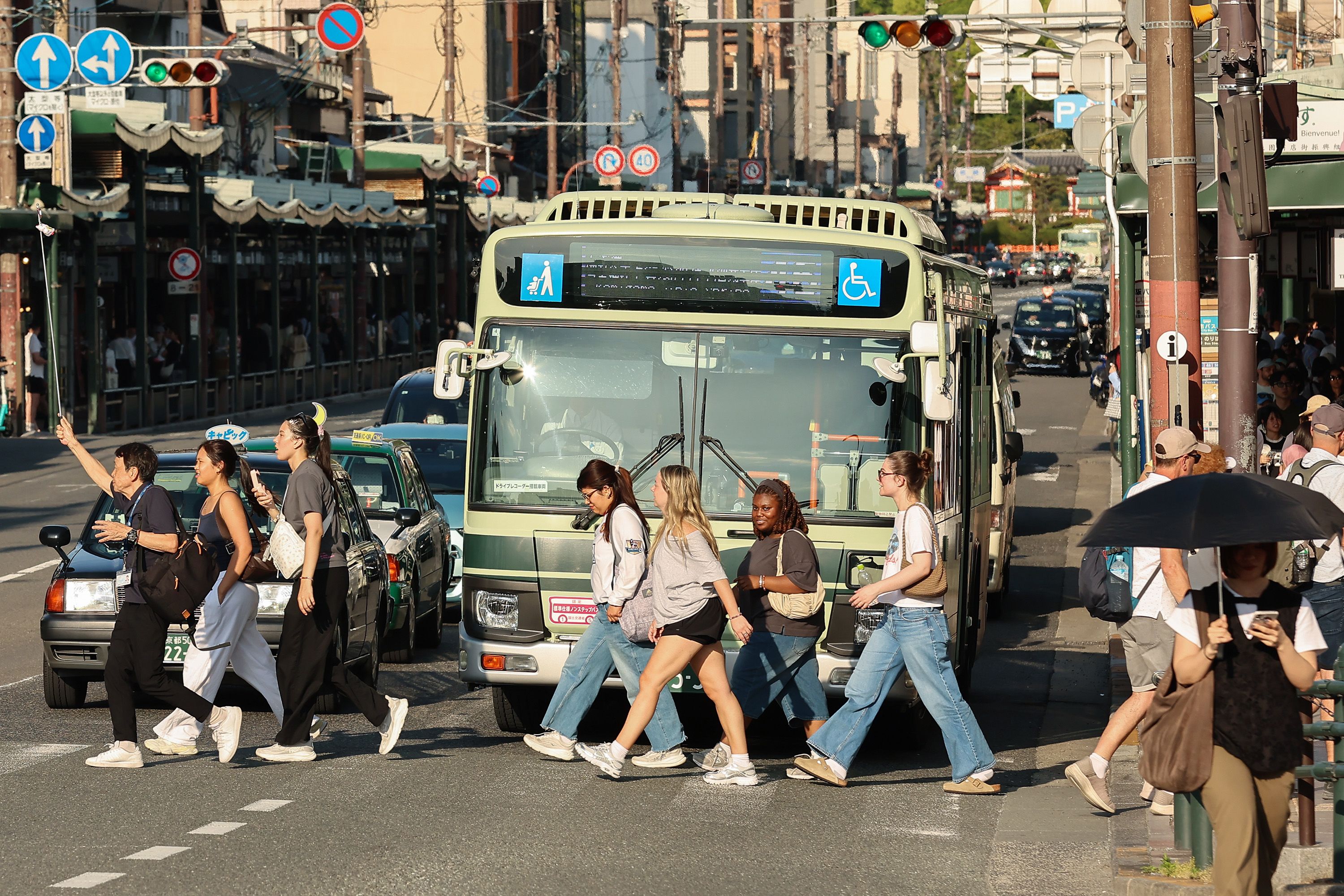 A tourist group crosses the street near the Yasaka Shrine in Kyoto.
