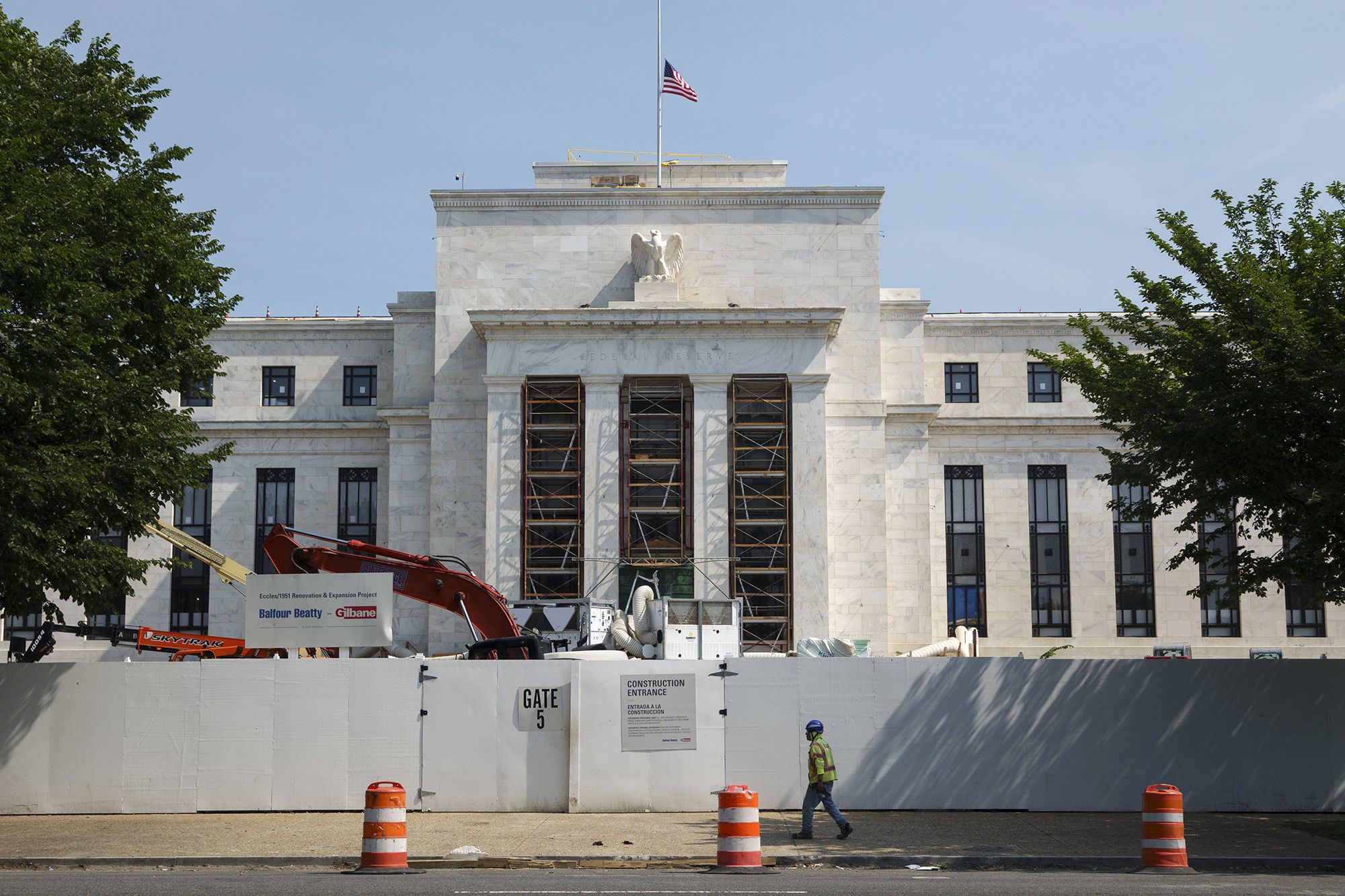 A construction worker walks by the Federal Reserve Building in Washington, DC, on July 15.