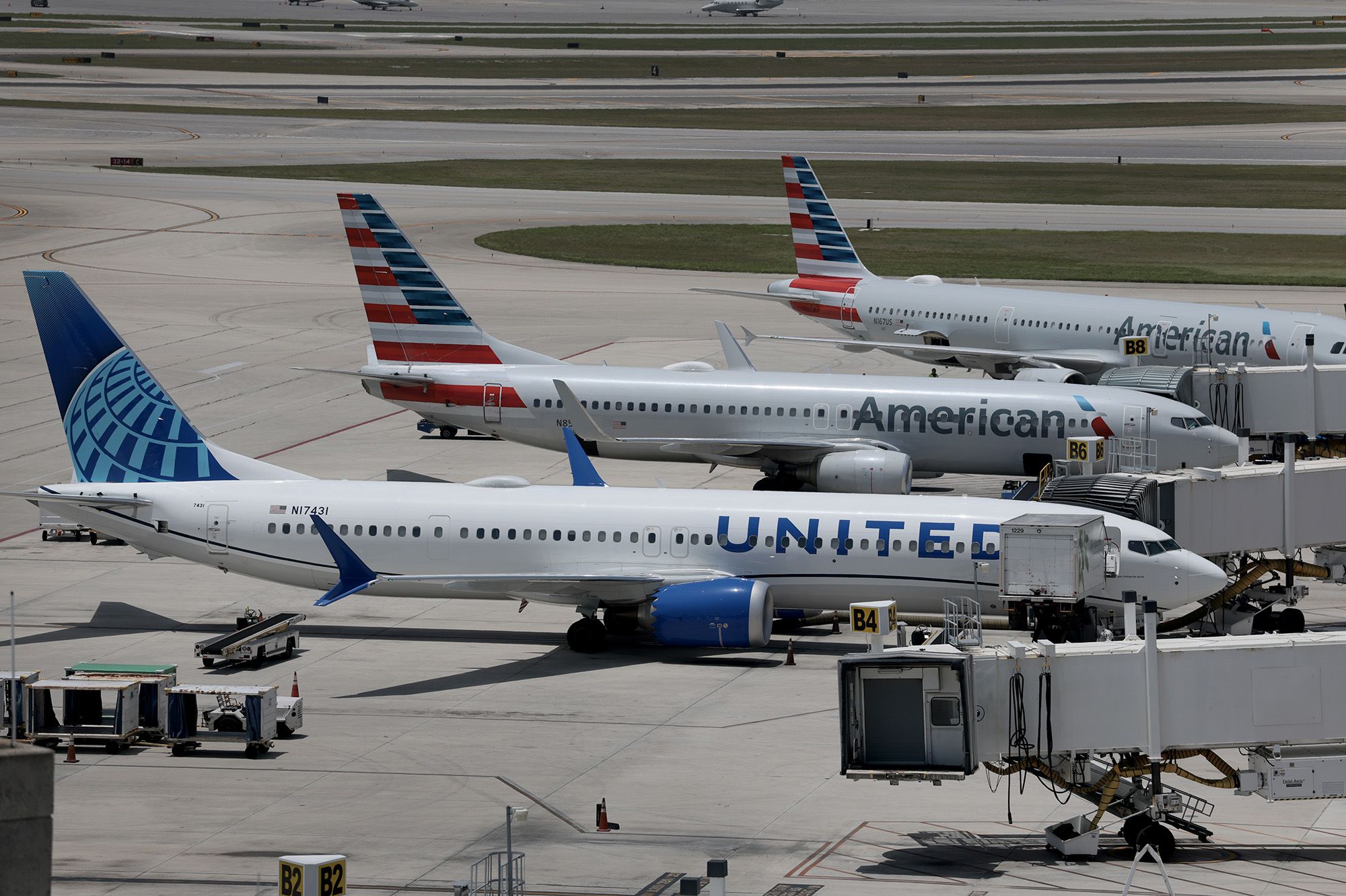 Airplanes parked at their gates in Palm Beach, Florida. Airlines, including American, are cutting their flight schedule for the rest of the year due to higher fuel costs.