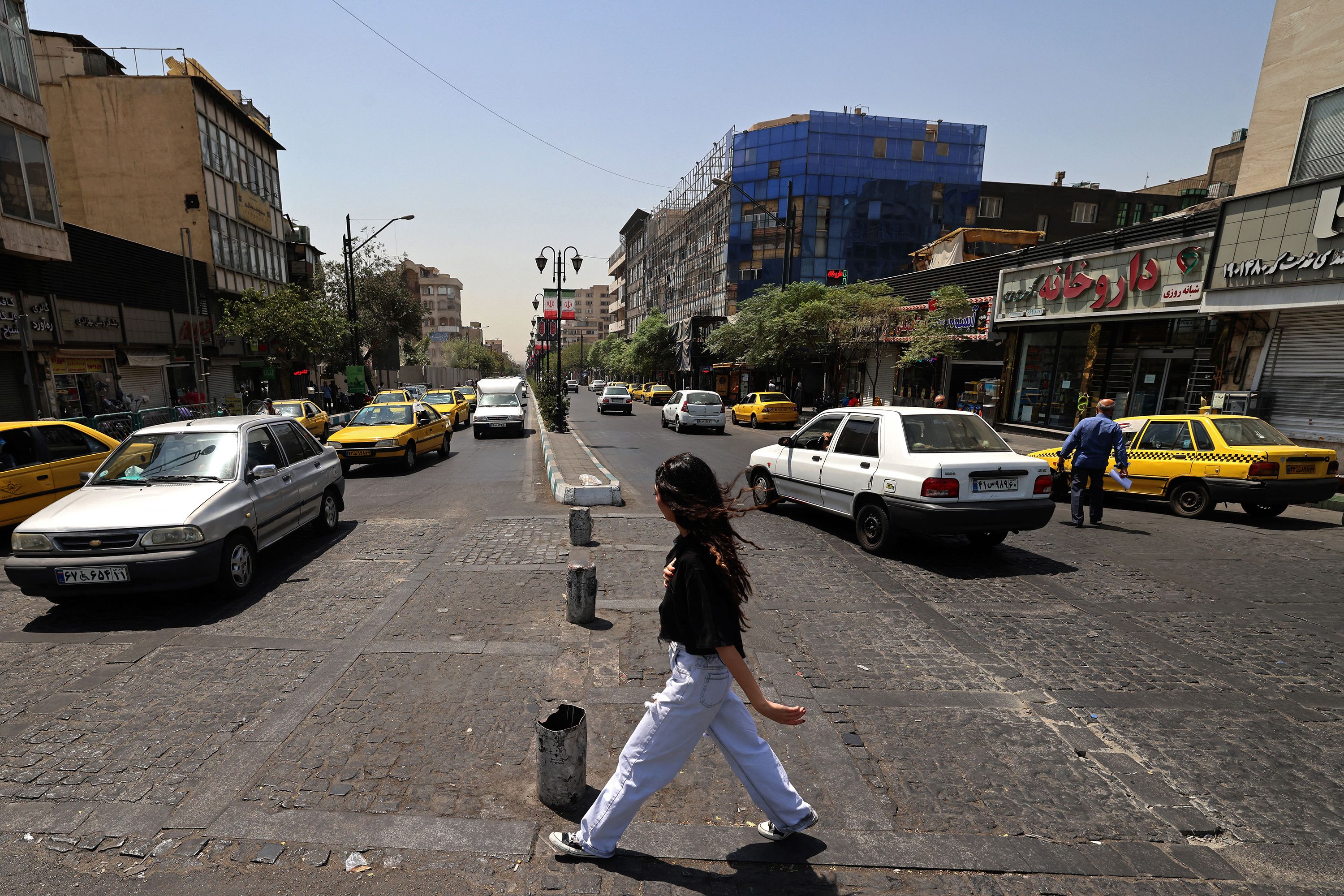A girl crosses a busy road at the Islamic Revolution Square in Tehran on July 21.