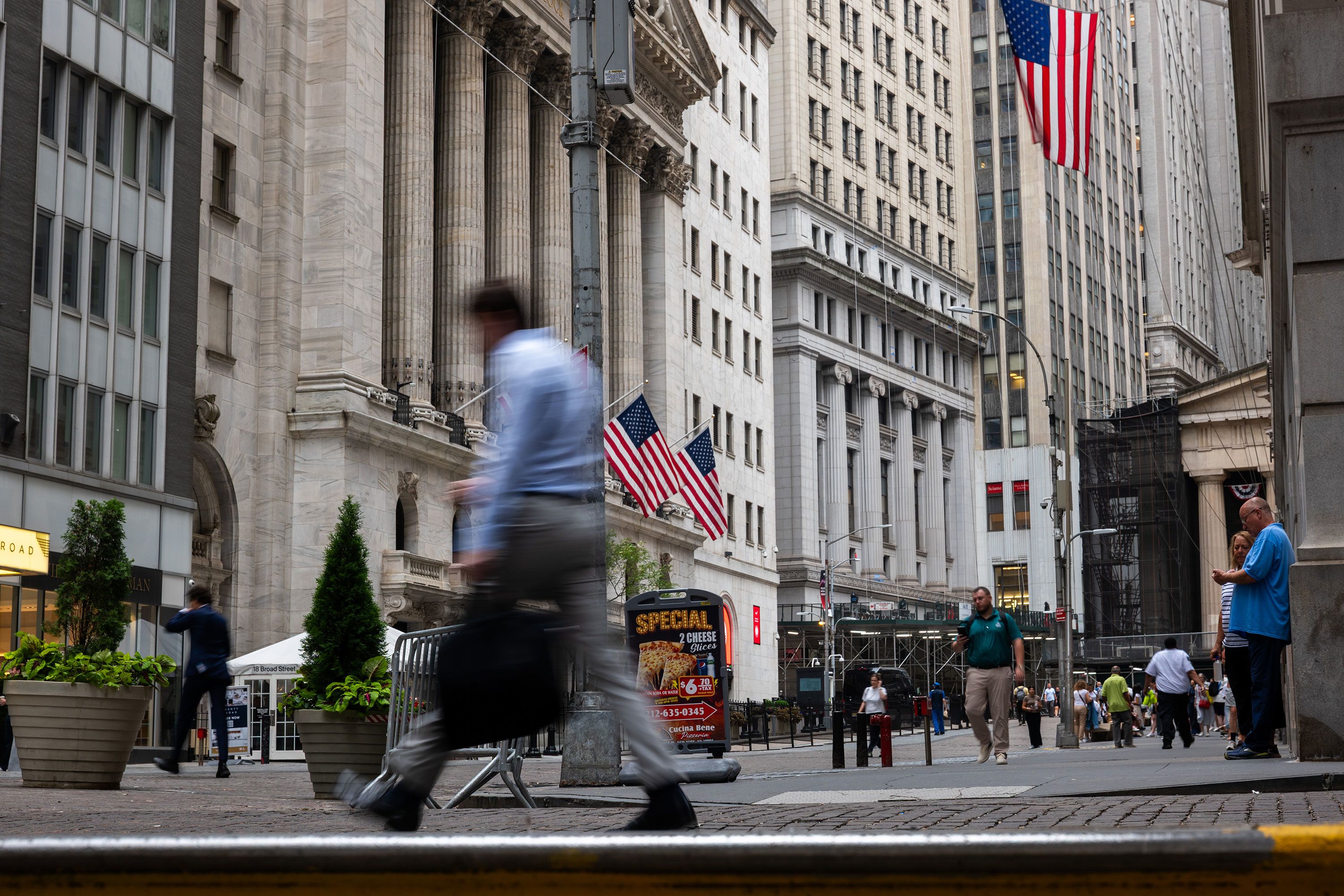 People walk by the New York Stock Exchange on July 21, 2026, in New York.