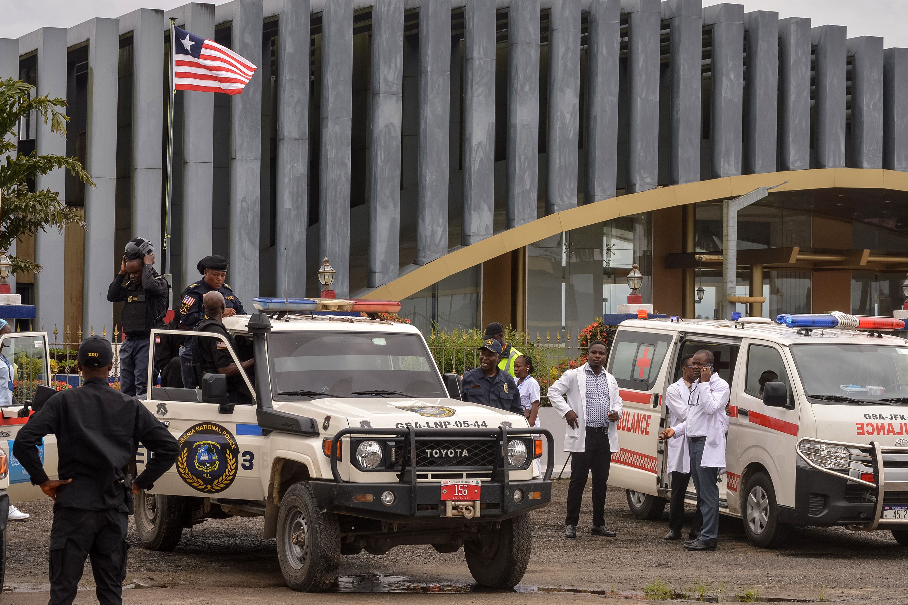 Liberia's national police officers stand guard for a plane carrying migrants deported from the US at the Roberts International Airport in Harbel, some 56 km outside Liberia's capital, Monrovia, on August 20, 2026.