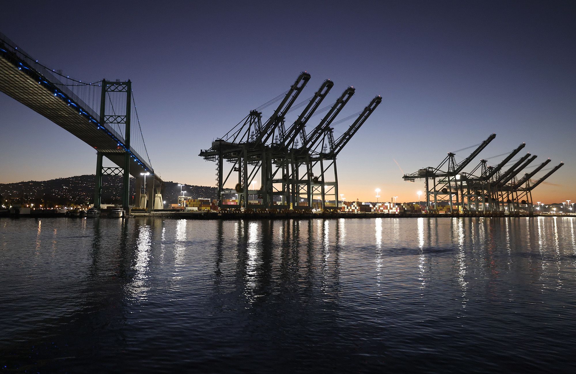 Shipping cranes stand near the Vincent Thomas Bridge at the Port of Los Angeles on August 19, 2026 in Los Angeles, California.