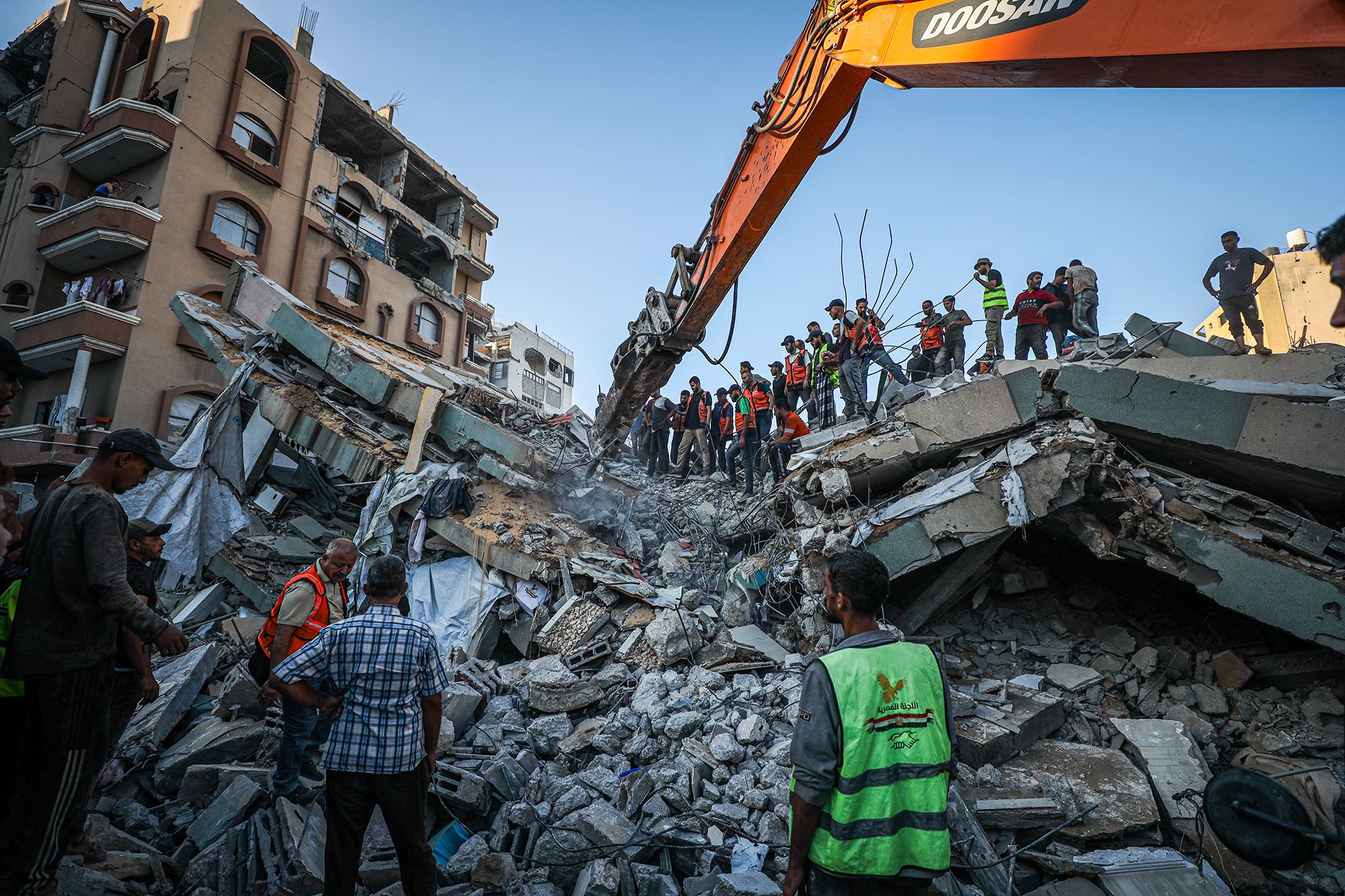 Rescue workers extract bodies from the rubble after a previously damaged six-story building collapsed in Gaza City on Wednesday.