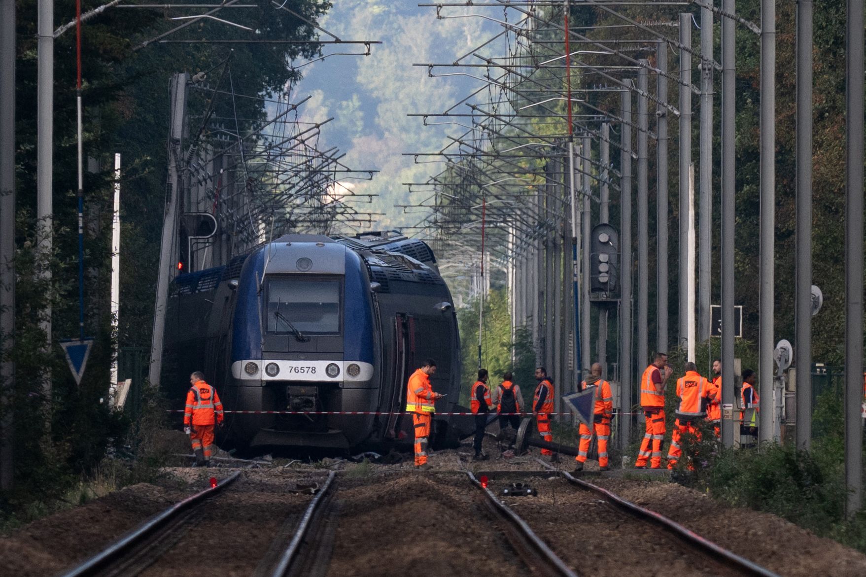 SNCF agents walk around a crashed train in Cleon, northwestern France, on September 12, 2026, one day after a train carrying 180 passengers derailed, injuring4 44 people. In total 44 people were injured, including a young woman evacuated "in absolute emergency" in the derailment on the evening of September 11, 2026, of a TER train that was carrying 186 passengers between Rouen and Caen, according to the Seine-Maritime prefecture and the public prosecutor's office.