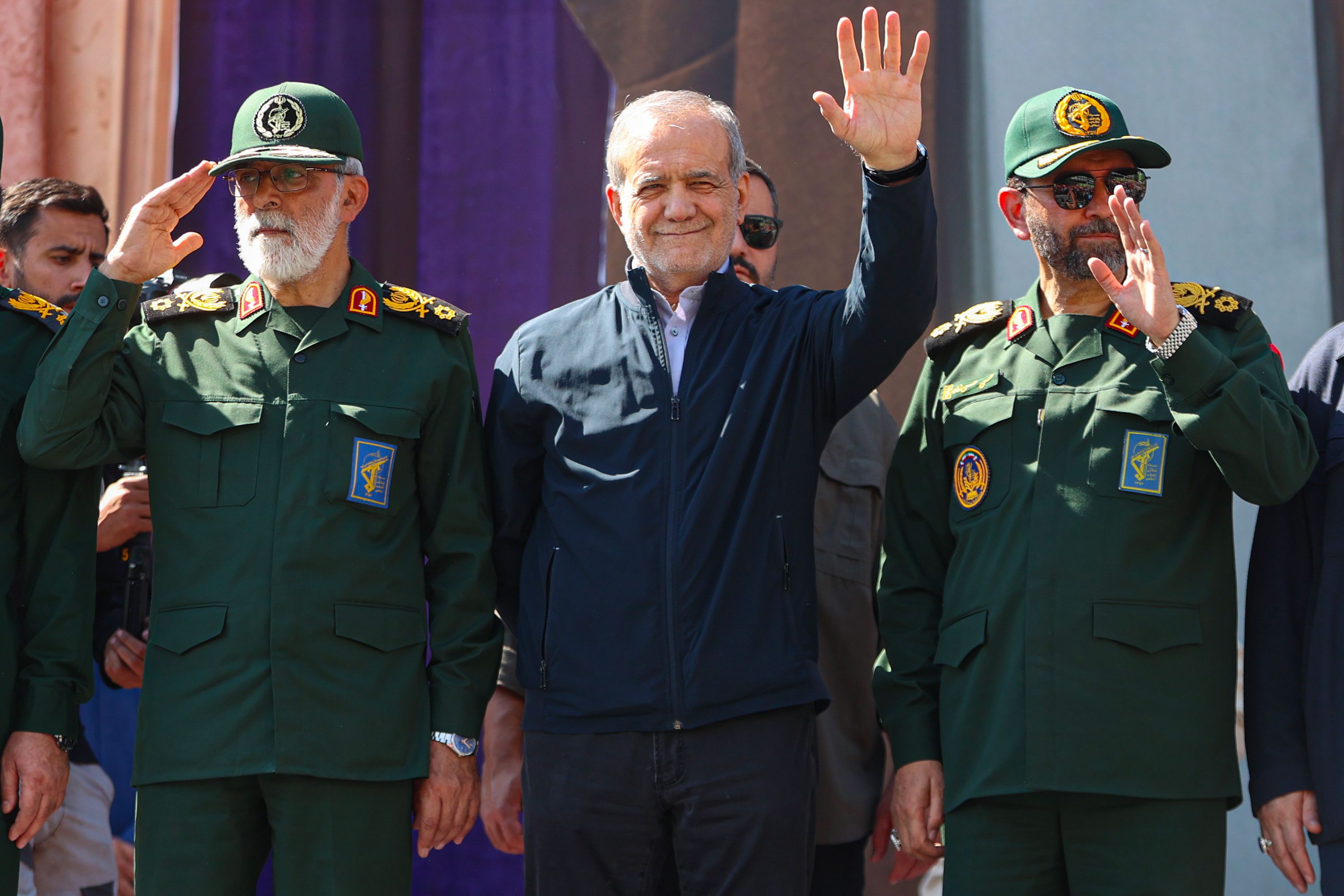 Iranian President Masoud Pezeshkian waves as demonstrators in Tehran chant slogans against the US and Israel on September 18.