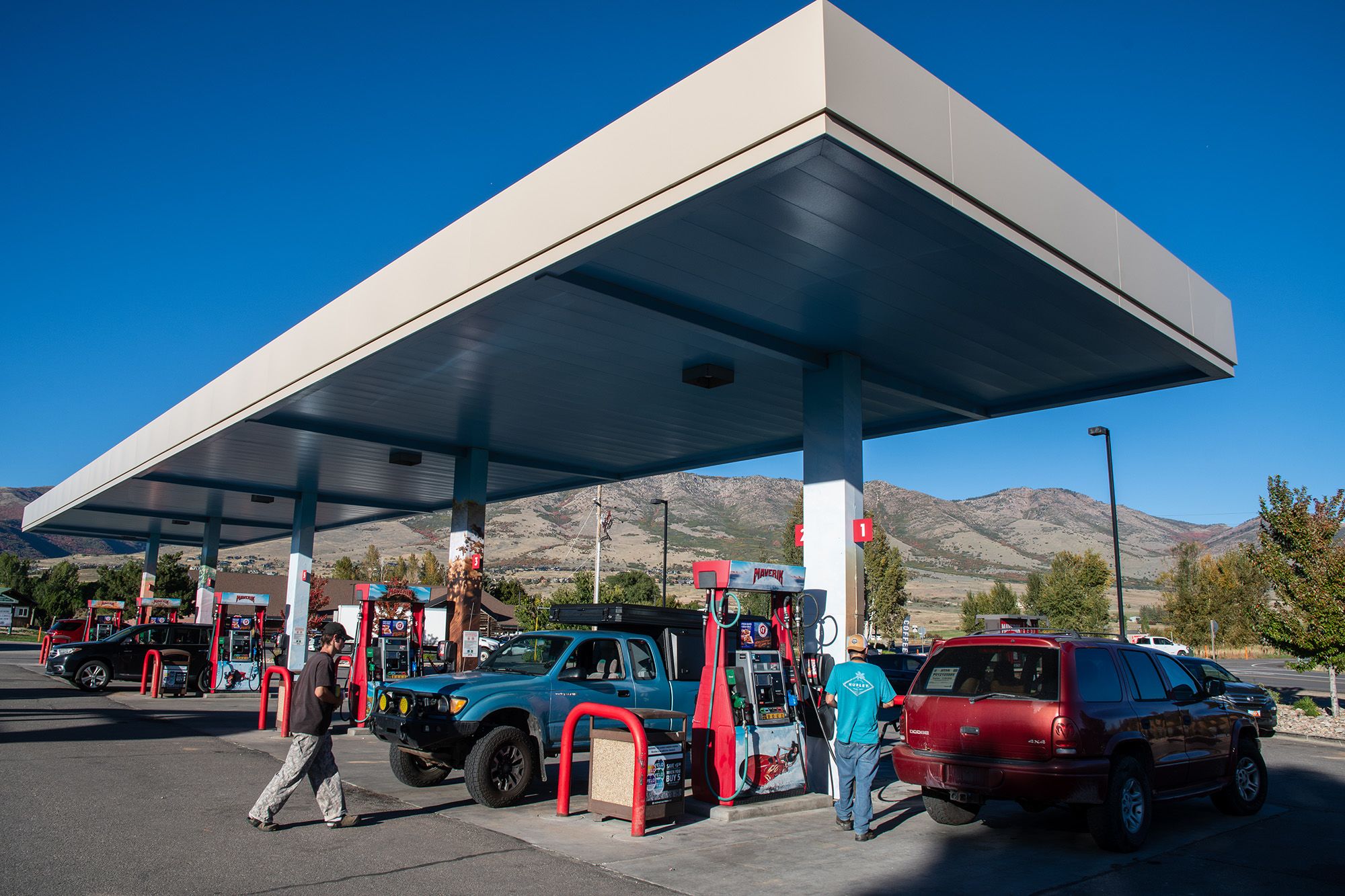 Multiple vehicles are parked under a fuel station canopy with motorists refueling at retail pumps in Salt Lake City, Utah, on September 30, 2026. Retail regular gasoline prices remain high across the United States, averaging roughly $4.43 to $4.60 per gallon nationwide due to ongoing global supply disruptions and commodity trading volatility.