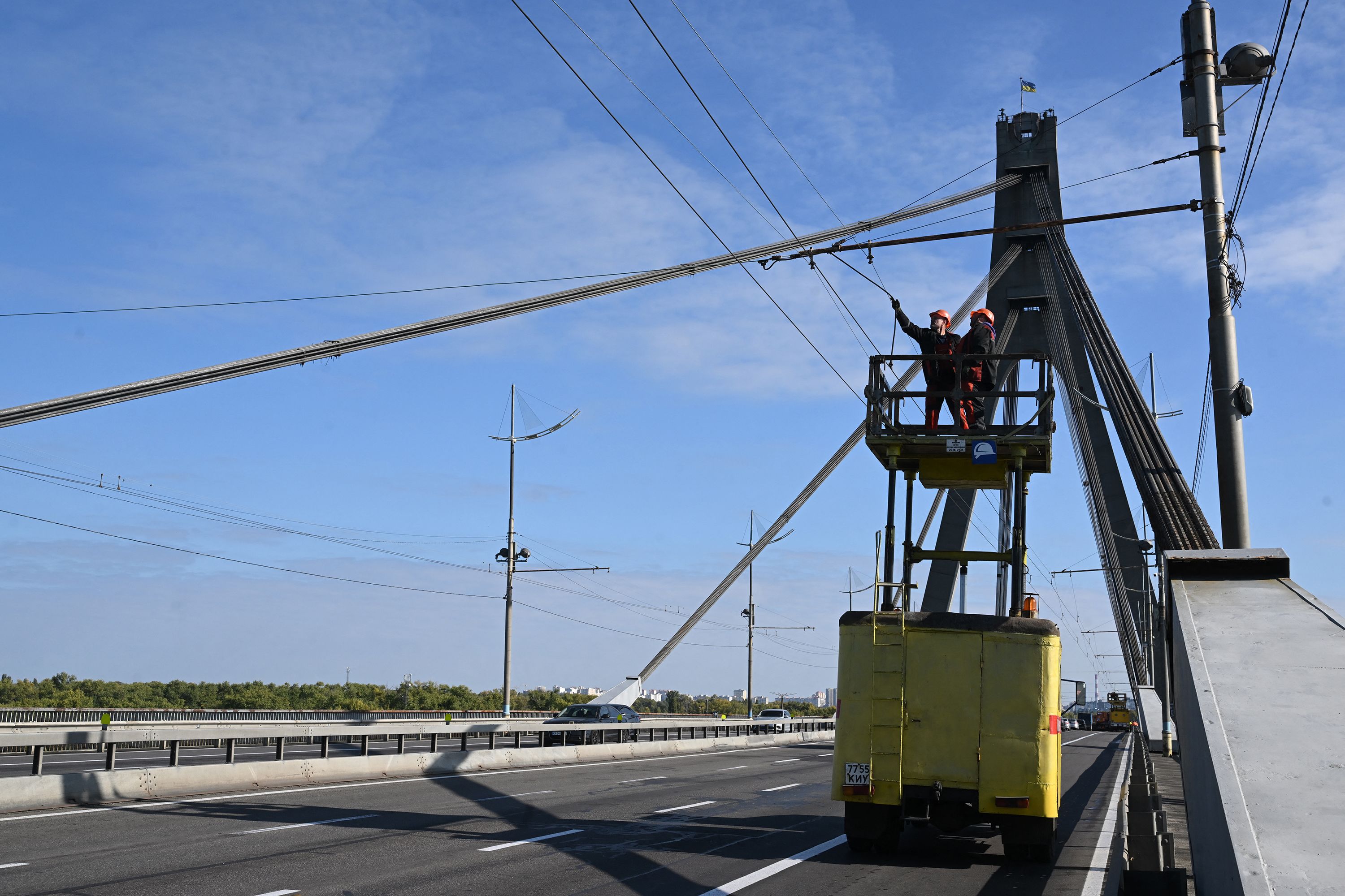 Technicians repair a trolleybus power line that was damaged following a drone attack on the Northern Bridge in Kyiv on October 3, 2026, amid Russian invasion of Ukraine. A Russian strike targeted a major bridge in Kyiv, its mayor said October 3, in another attack on Ukrainian infrastructure that has brought traffic chaos to the capital. The attack on the Northern Bridge, which followed a drone alert, came a day after the Southern Bridge was hit in a wave of strikes that city officials say is "tearing Kyiv apart".
