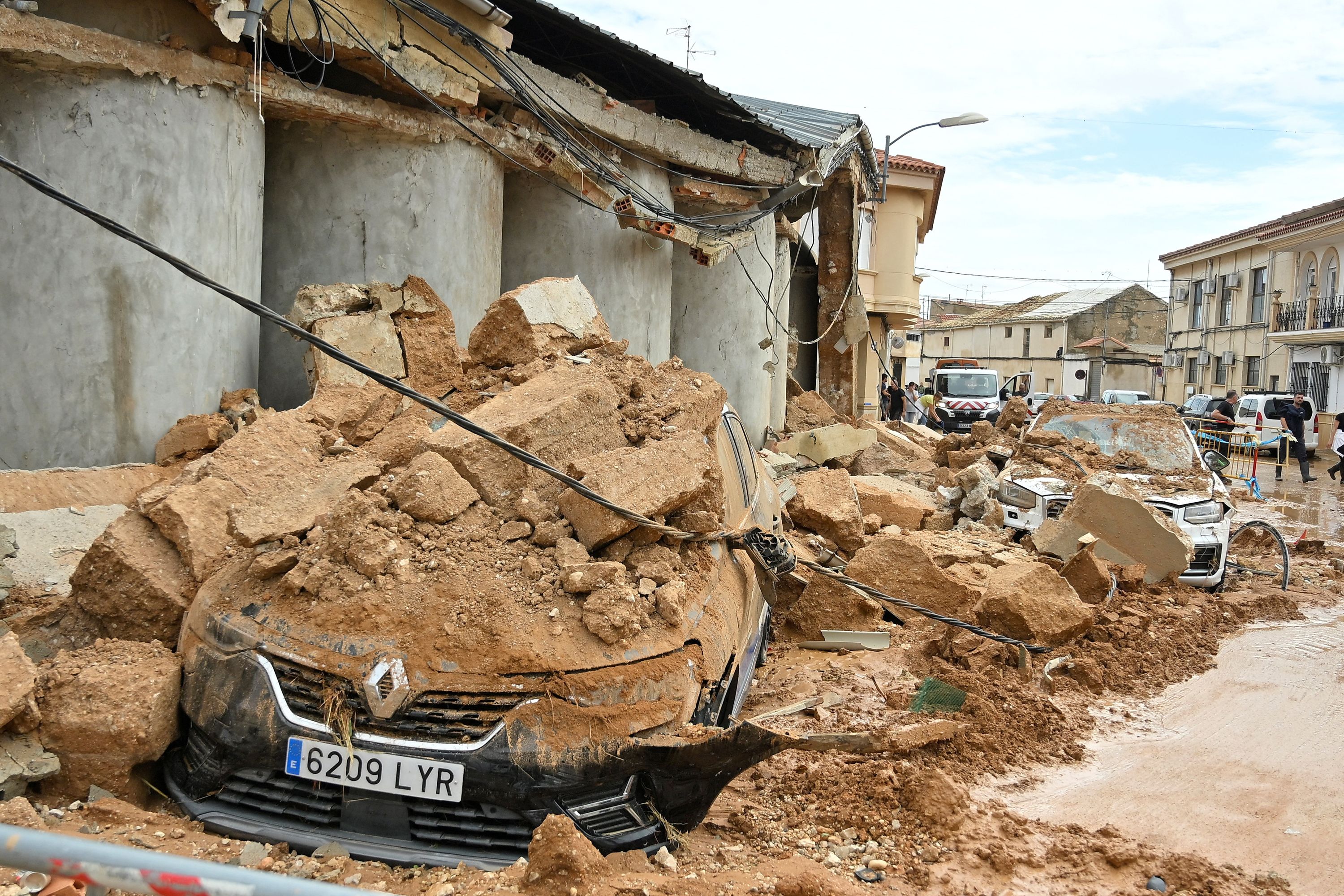 A car is seen covered in debris next to building partially collapsed following floods in Madrigueras, near Albacete, southeastern Spain, on Saturday.