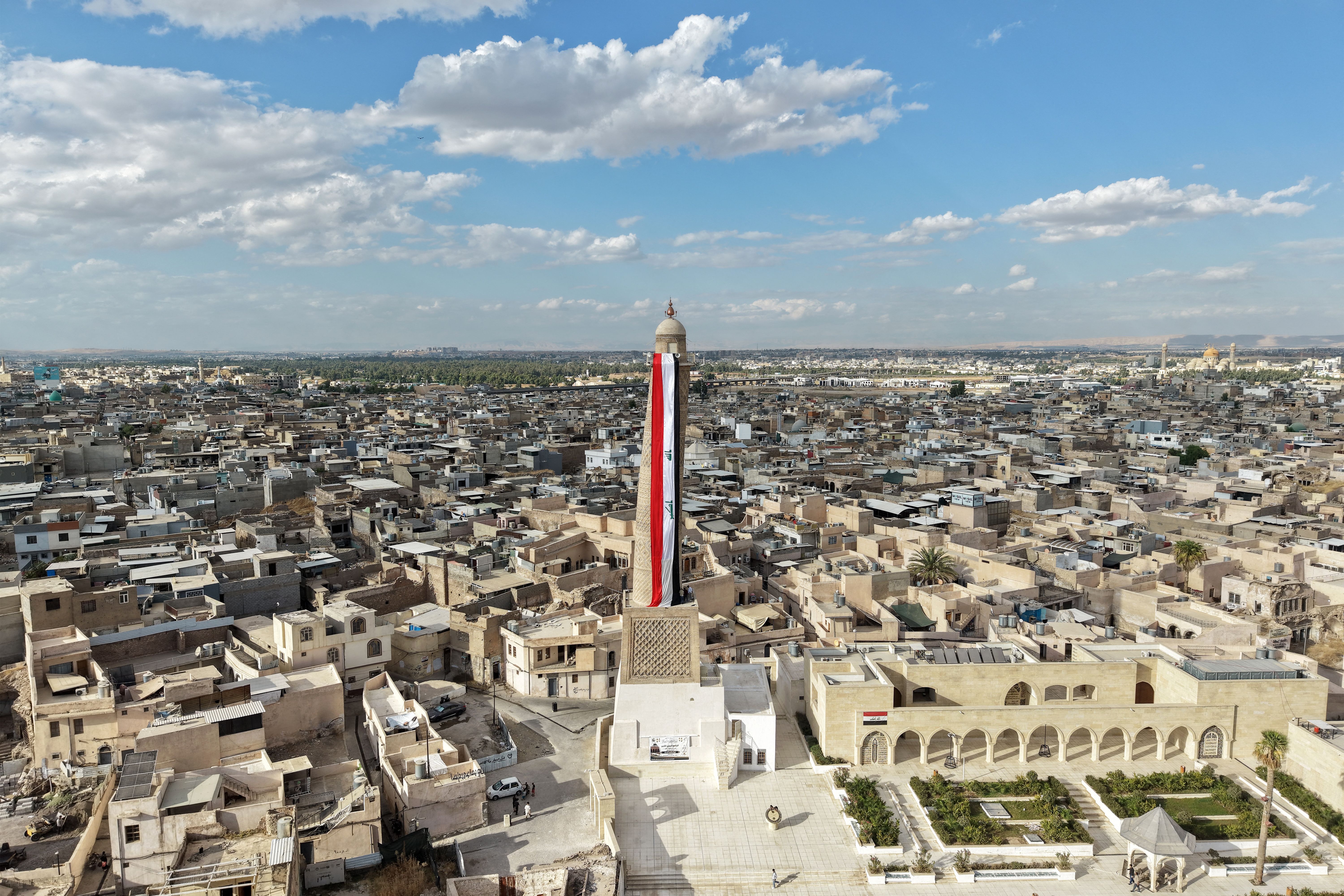 A giant Iraqi flag hangs off the reconstructed 12th century "Hadba" leaning minaret at the historic Great Mosque of al-Nuri in the old city of Mosul on September 29, 2026 as Iraq marks the withdrawal of the US-led anti-Islamic State coalition forces from the country.