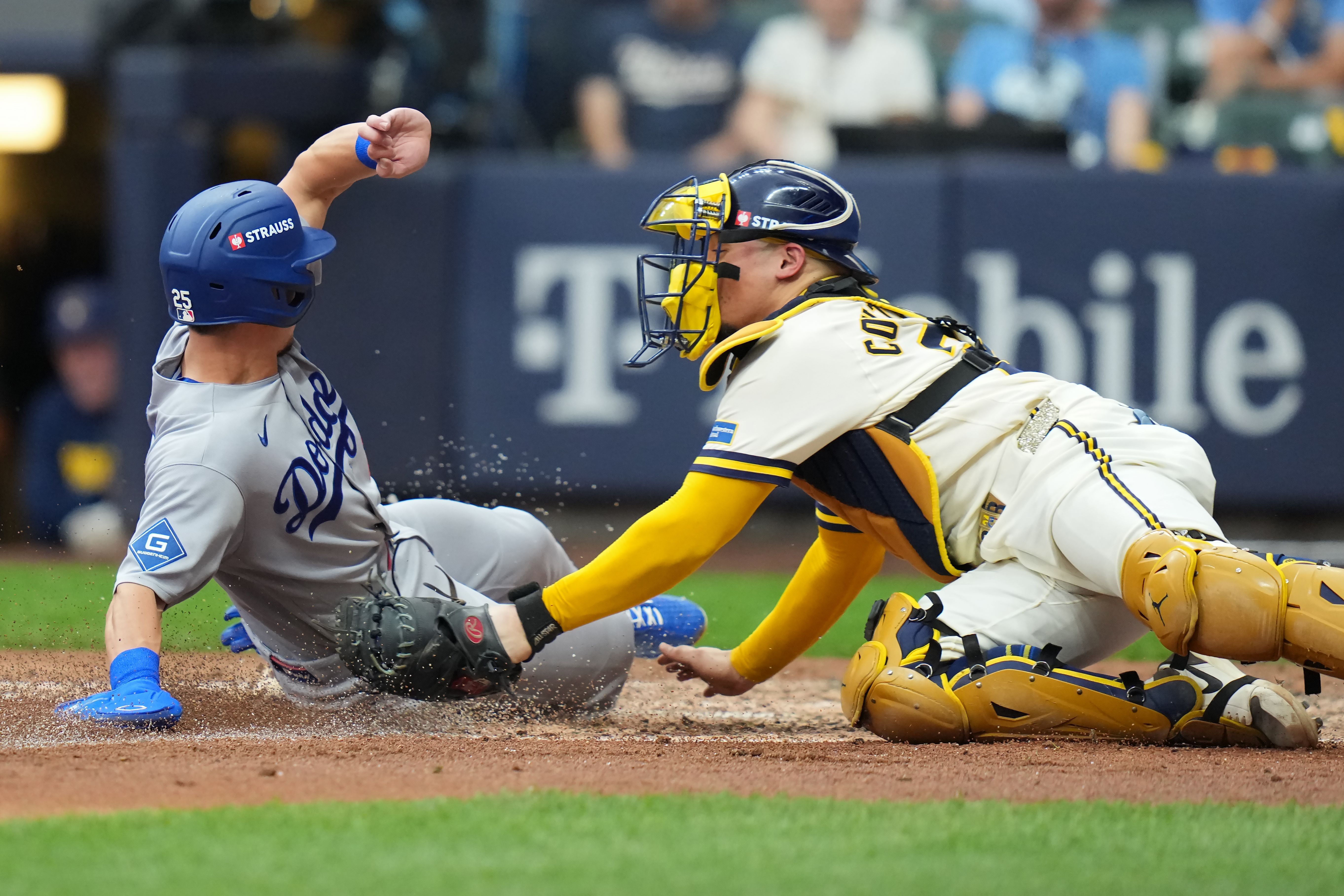 MILWAUKEE, WISCONSIN - OCTOBER 12: Tommy Edman #25 of the Los Angeles Dodgers slides into home plate to score a run past William Contreras #24 of the Milwaukee Brewers in the fifth inning in game two of the National League Championship Series at American Family Field on October 12, 2026 in Milwaukee, Wisconsin.  (Photo by John Fisher/Getty Images)