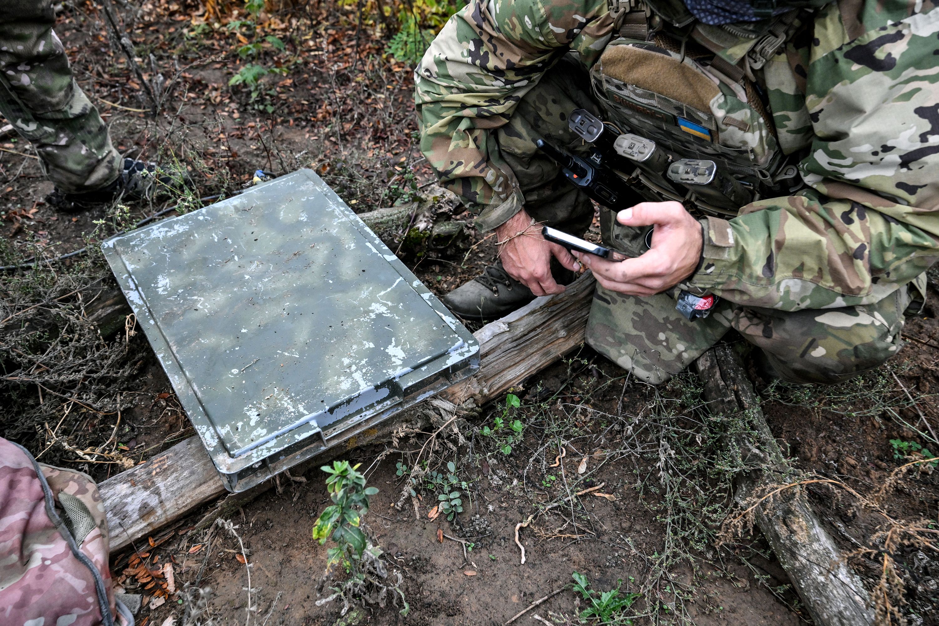 A soldier from a separate task rifle battalion of the National Police of Ukraine uses a smartphone to check signal quality while setting up a Starlink satellite communication network at a combat position in the Donetsk region, Ukraine, on October 16, 2026.