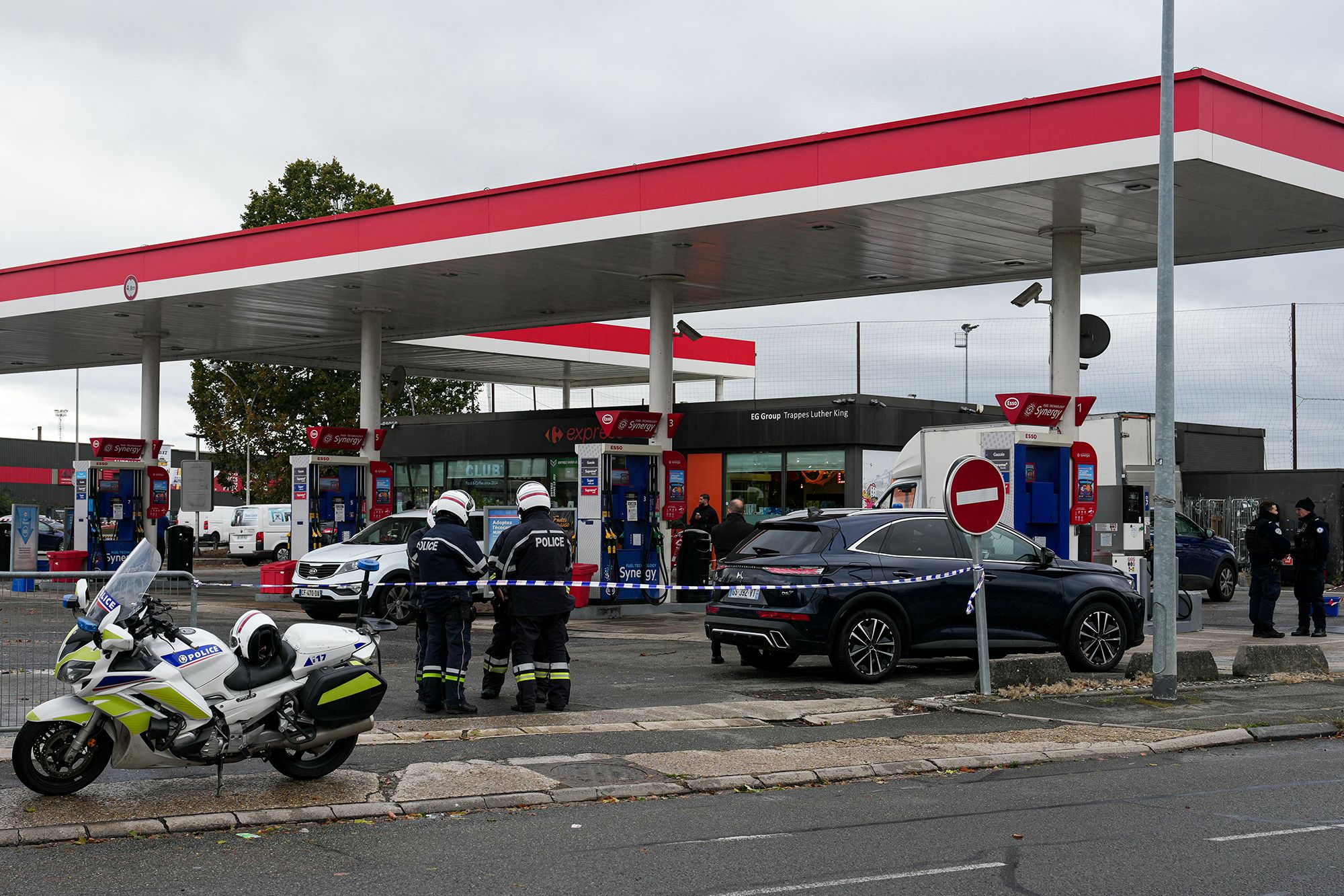 Police officers at the scene where a man opened fire from his car in a suburb of Paris, France, on Friday.