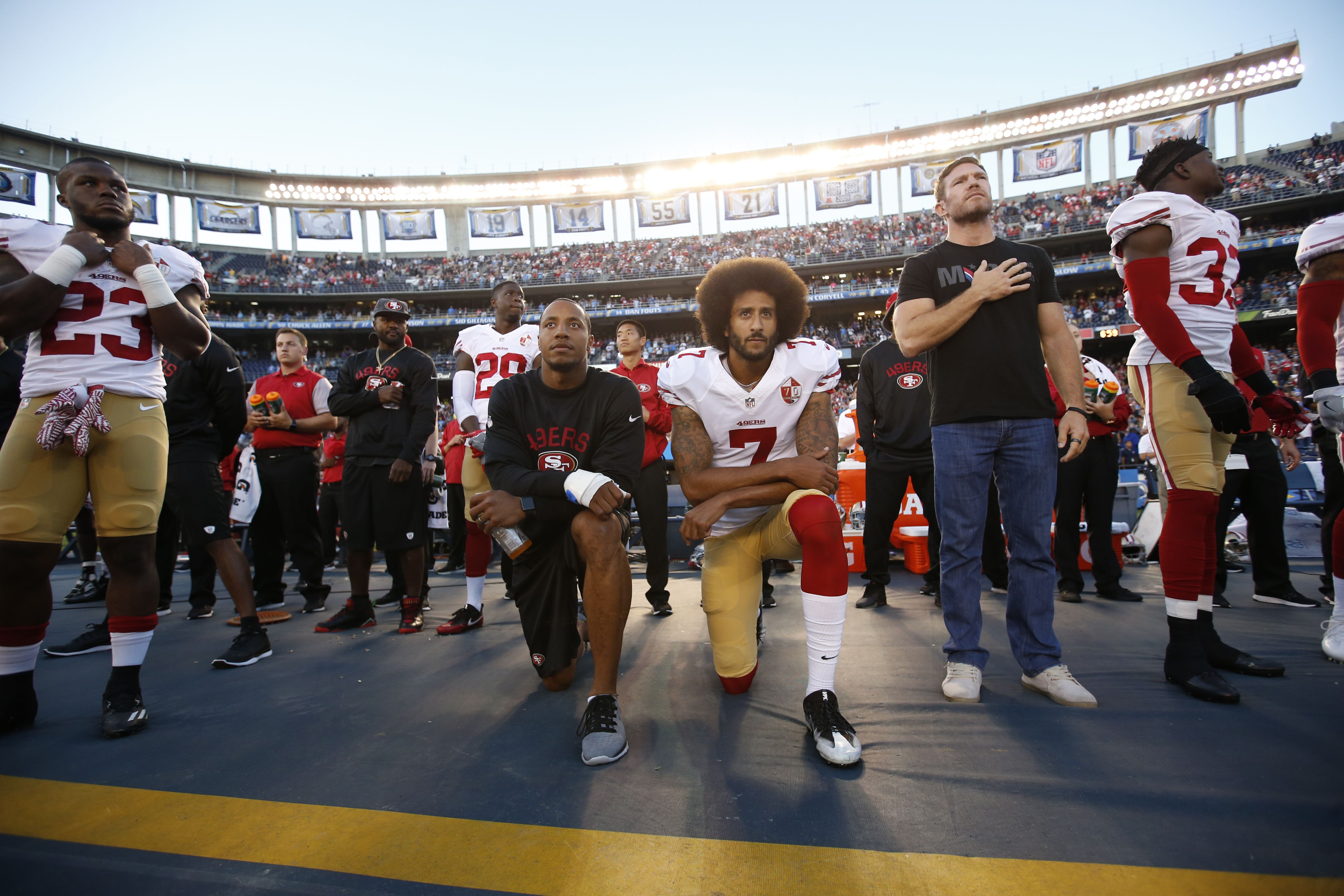 Colin Kaepernick and Eric Reid of the San Francisco 49ers kneel on the sideline during the national anthem on September 1, 2016 in San Diego, California.