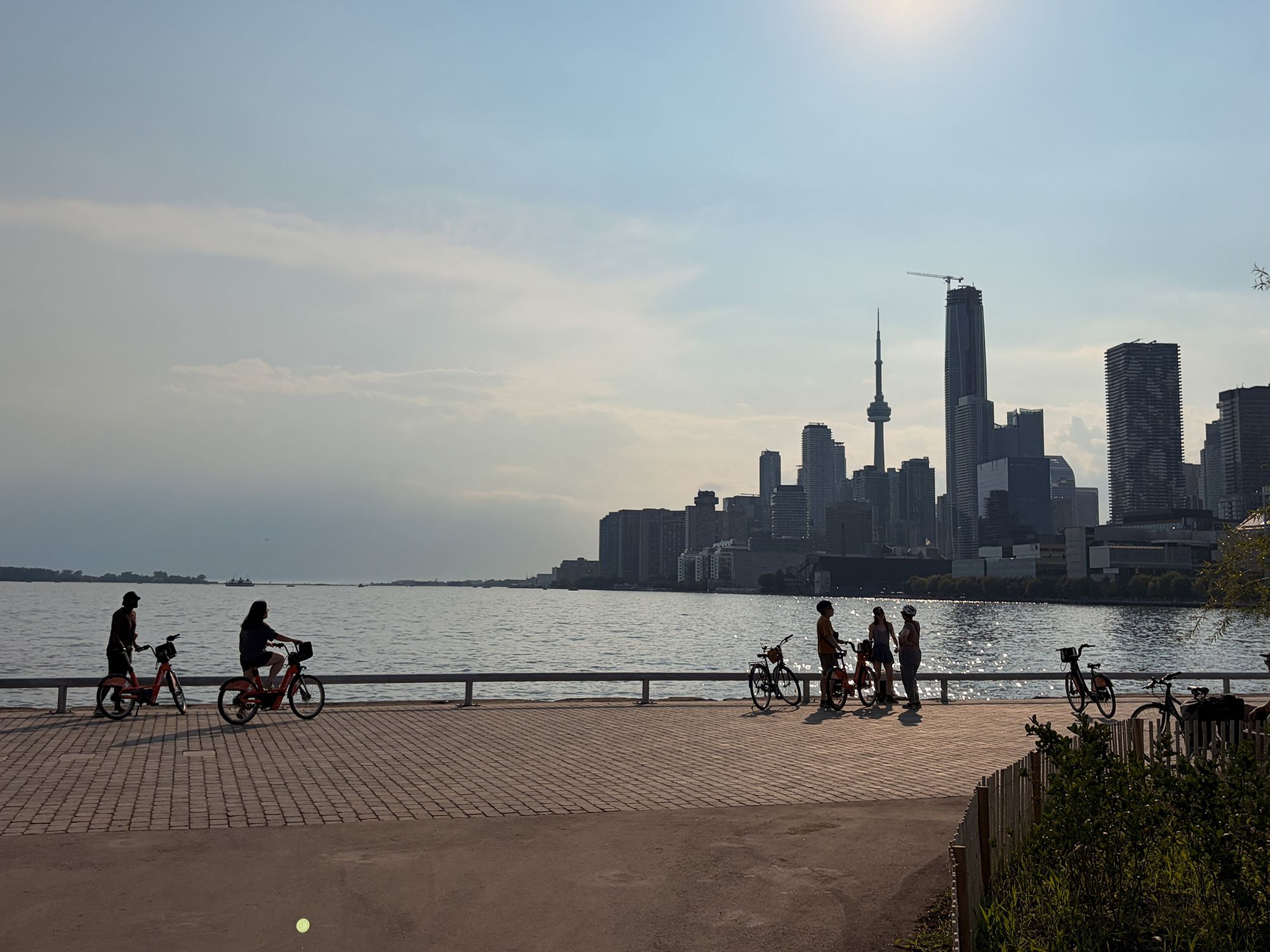 A general view of Biidaasige Park's waterfront, with cyclists in the newly expanded park and the Toronto skyline, including the CN Tower, visible in the background, Toronto, Ontario, Canada, on July 26, 2026.