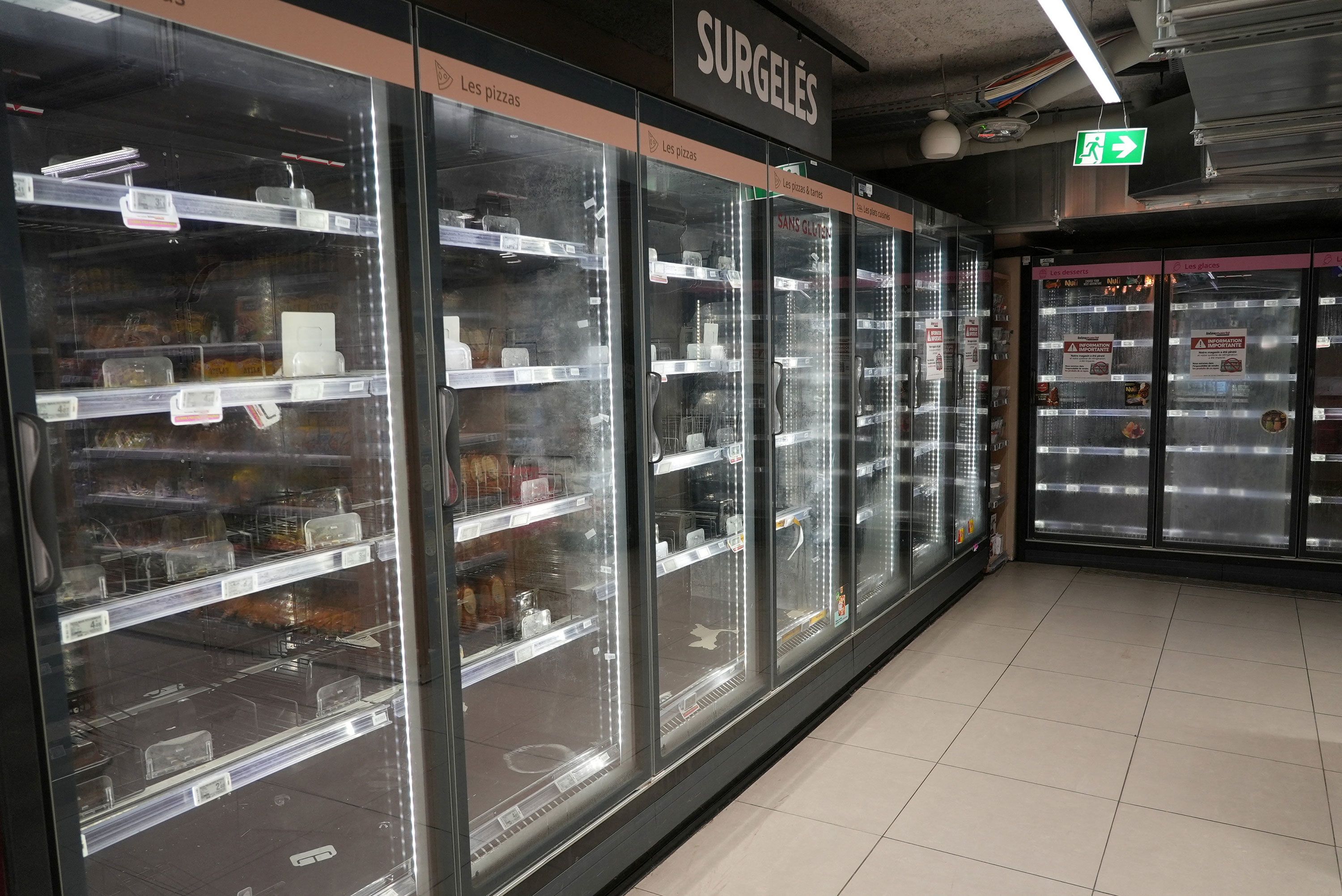 View of empty refrigerators in the frozen food aisle of an Intermarché supermarket in Paris on Tuesday, a day after a nationwide cyberattack on refrigeration systems caused food losses and fires at several stores.