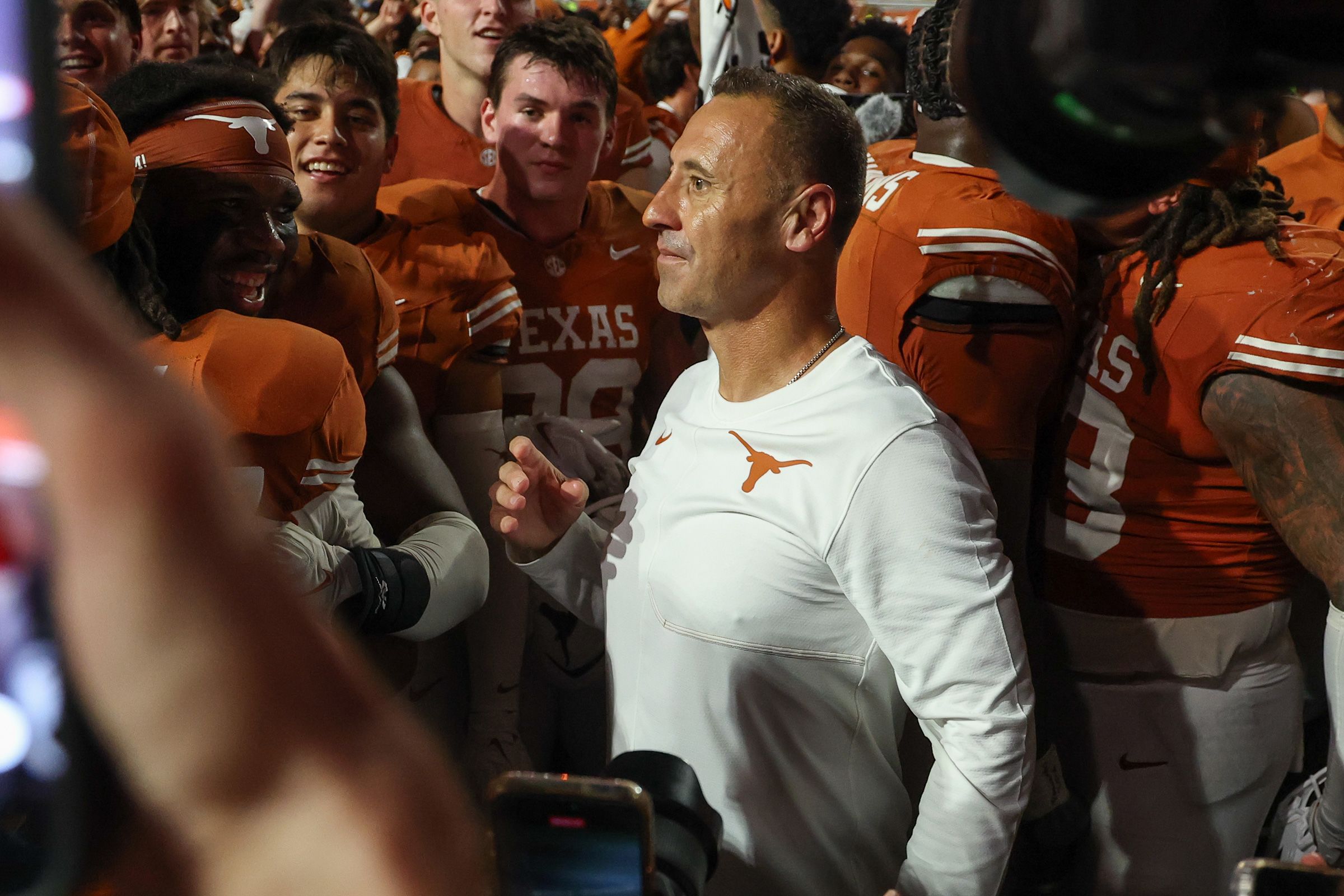 Longhorns head coach Steve Sarkisian stands with Texas players after beating Ohio State on Saturday.