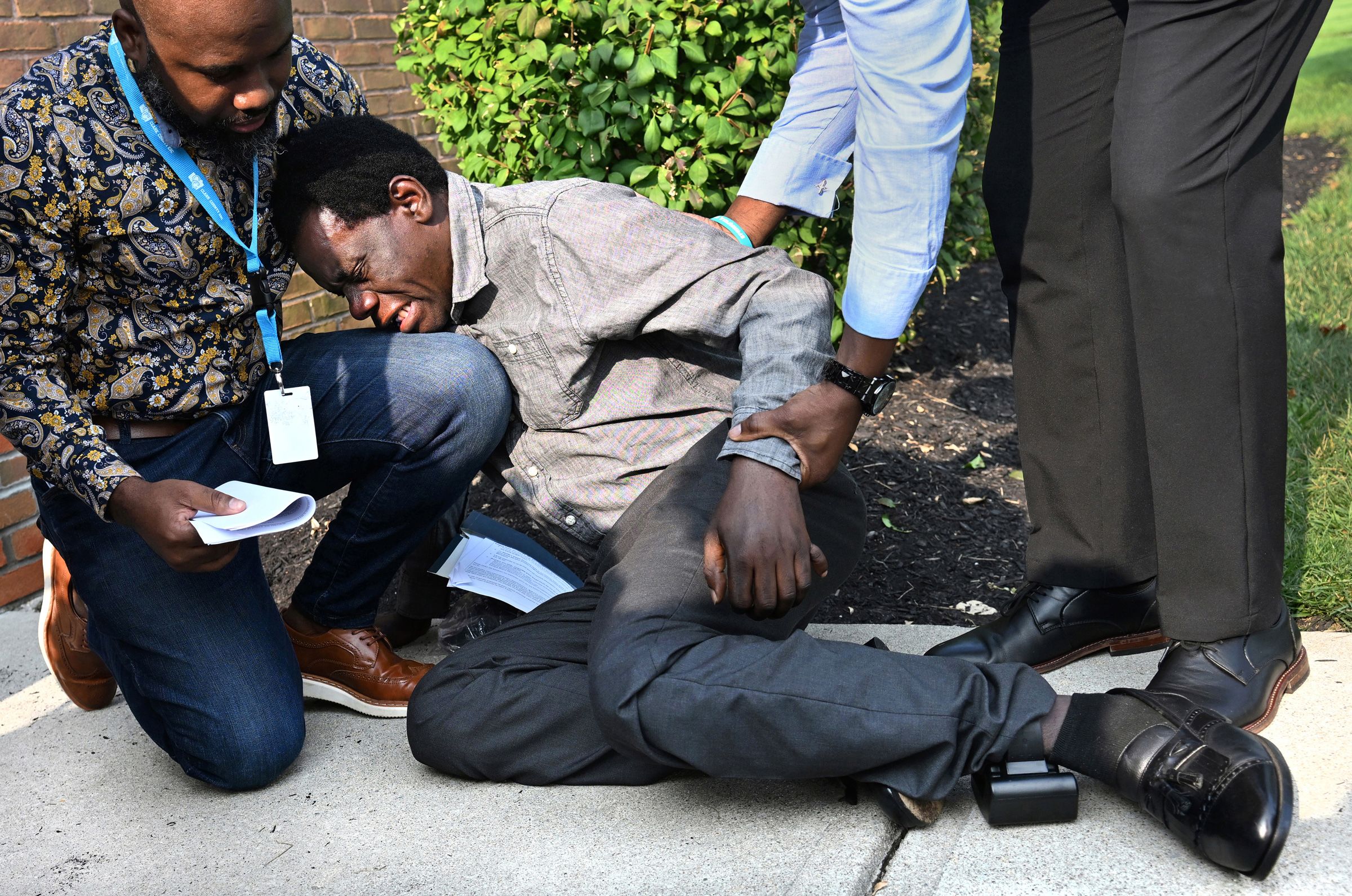 After receiving an ankle monitor during a check-in Sunday at an ICE field office in Blue Ash, Ohio, Haitian immigrant Monsanto Maler became emotional and collapsed outside. Now that a Supreme Court decision has cleared the way for the end of their deportation protections, advocates say many Haitians have been required to wear the ankle monitors. “It’s so humiliating,” says Vilès Dorsainvil of the Haitian Community Help and Support Center, one of the men comforting Maler in this photo. (Carol Guzy)Haitian immigrant Monsanto Maler became emotional and collapsed after receiving an ankle monitor at a Department of Homeland Security field office during a mandatory check in after thousands of Haitians lost Temporary Protected Status (TPS) during US President Trump’s controversial mass deportation effort in Blue Ash Ohio on August 9, 2026. He has lived in the US since 2023, saying he left Haiti because he didn’t feel safe. Haitians are fearful of an impending ICE immigration enforcement surge and being returned to their country which is still in the grip of anarchy and dangerous gang violence.
