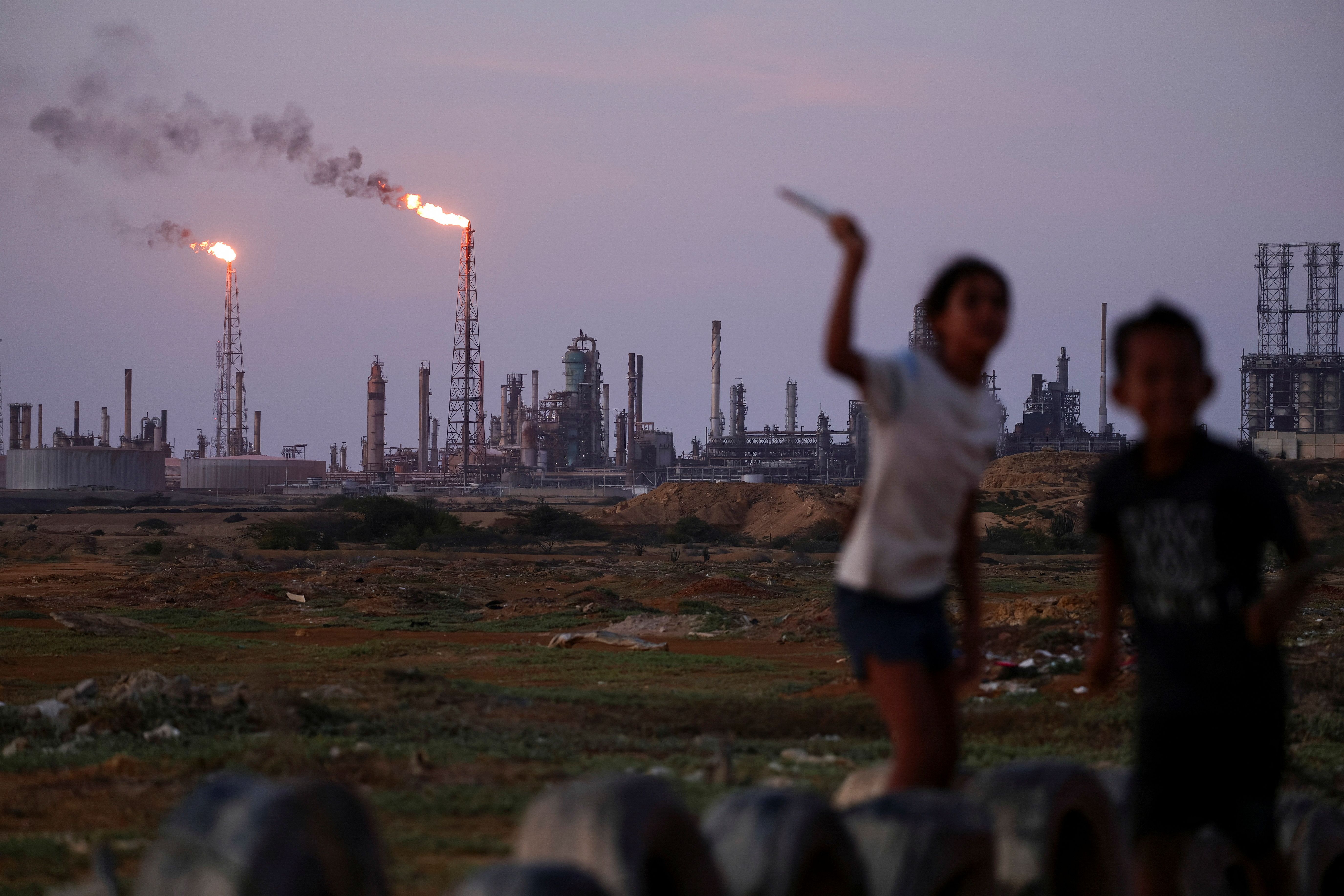 Children play near the Amuay refinery, part of the Paraguana Refining Center, as years of underinvestment, equipment failures and shortages have hampered fuel production in Venezuela, in Punto Fijo, Venezuela, on May 5, 2026.