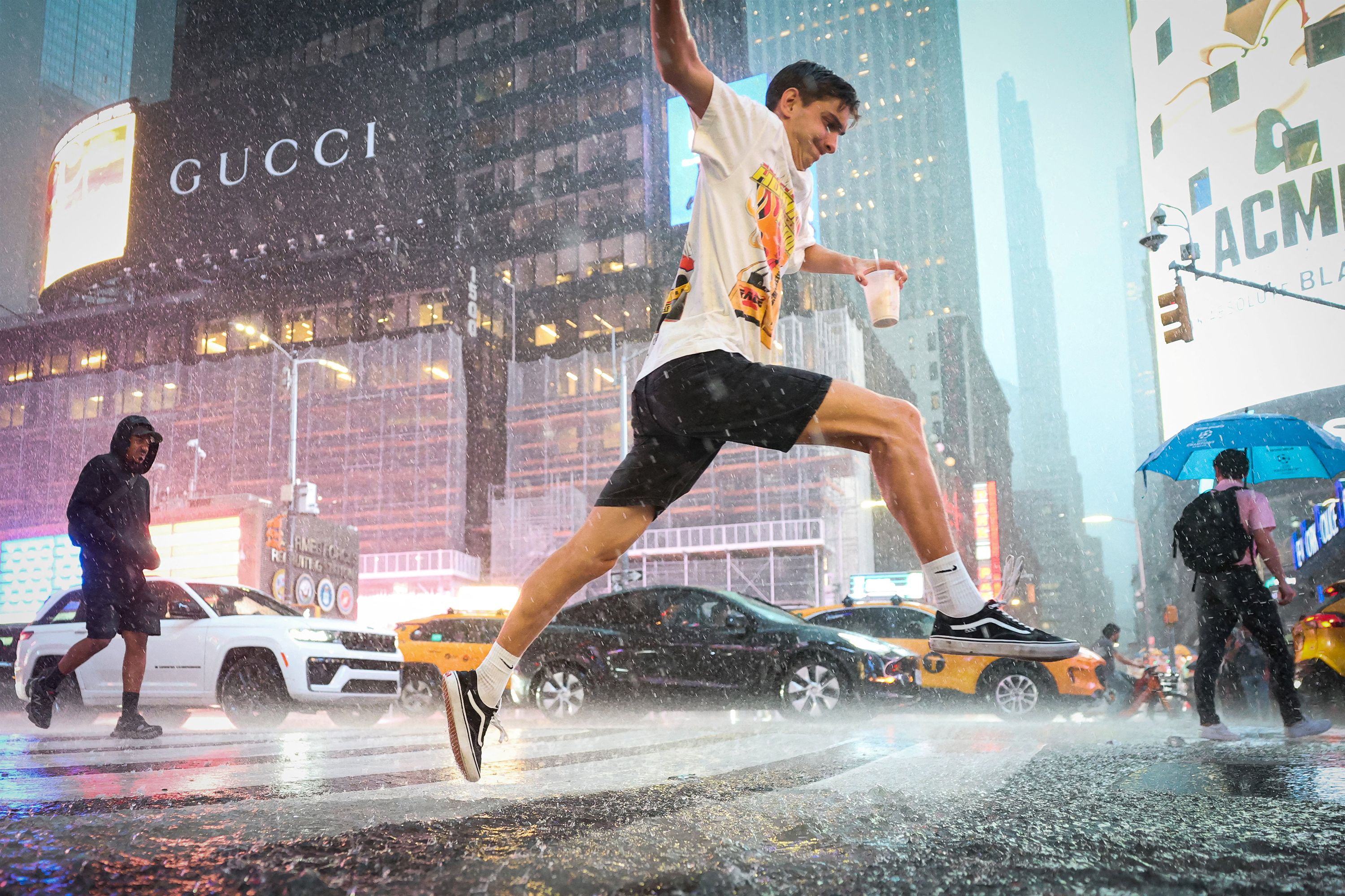 A man jumps over water in Times Square during a severe rain storm in New York on August 20.