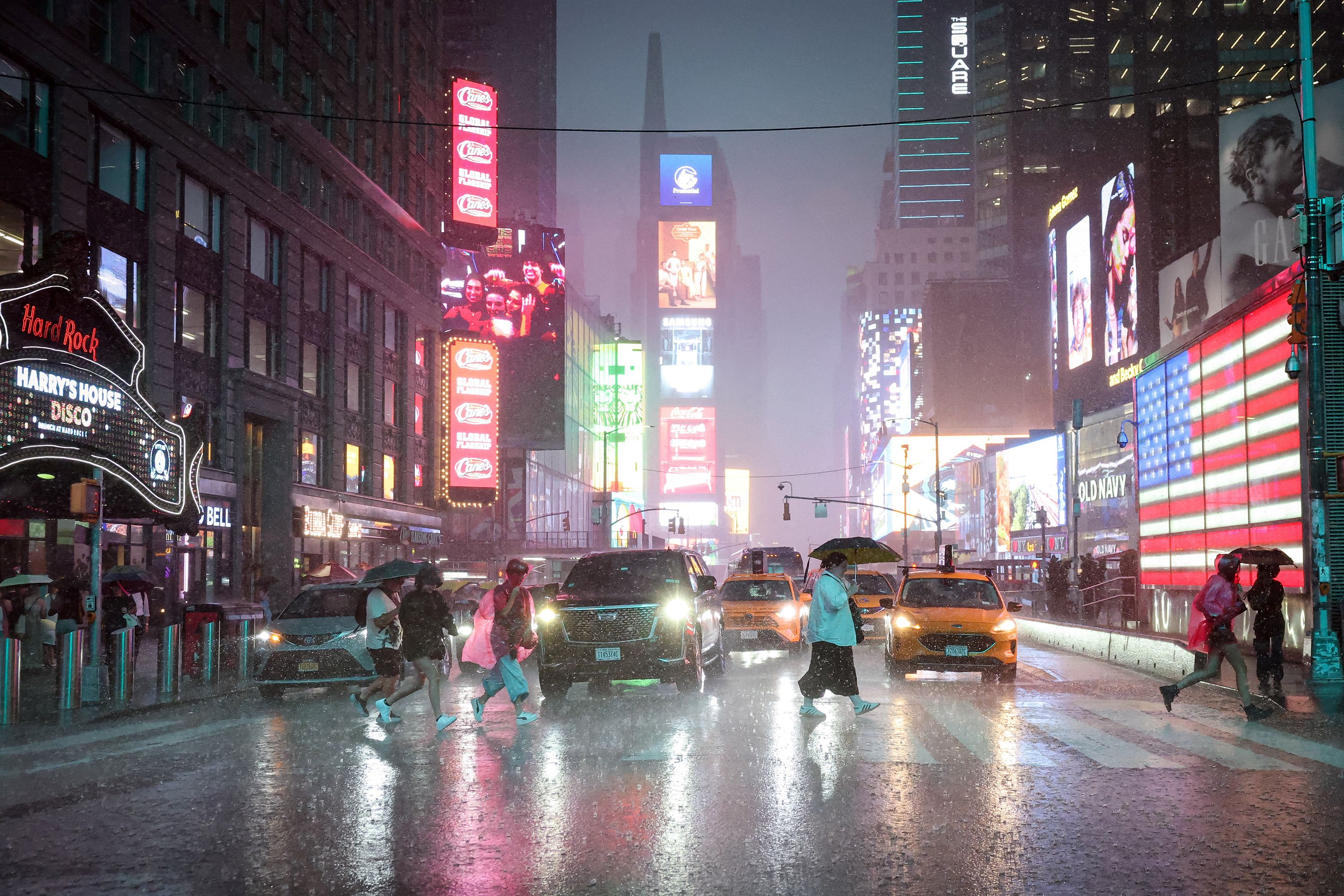 People cross through Times Square during a severe rain storm in New York City, U.S., August 20, 2026.