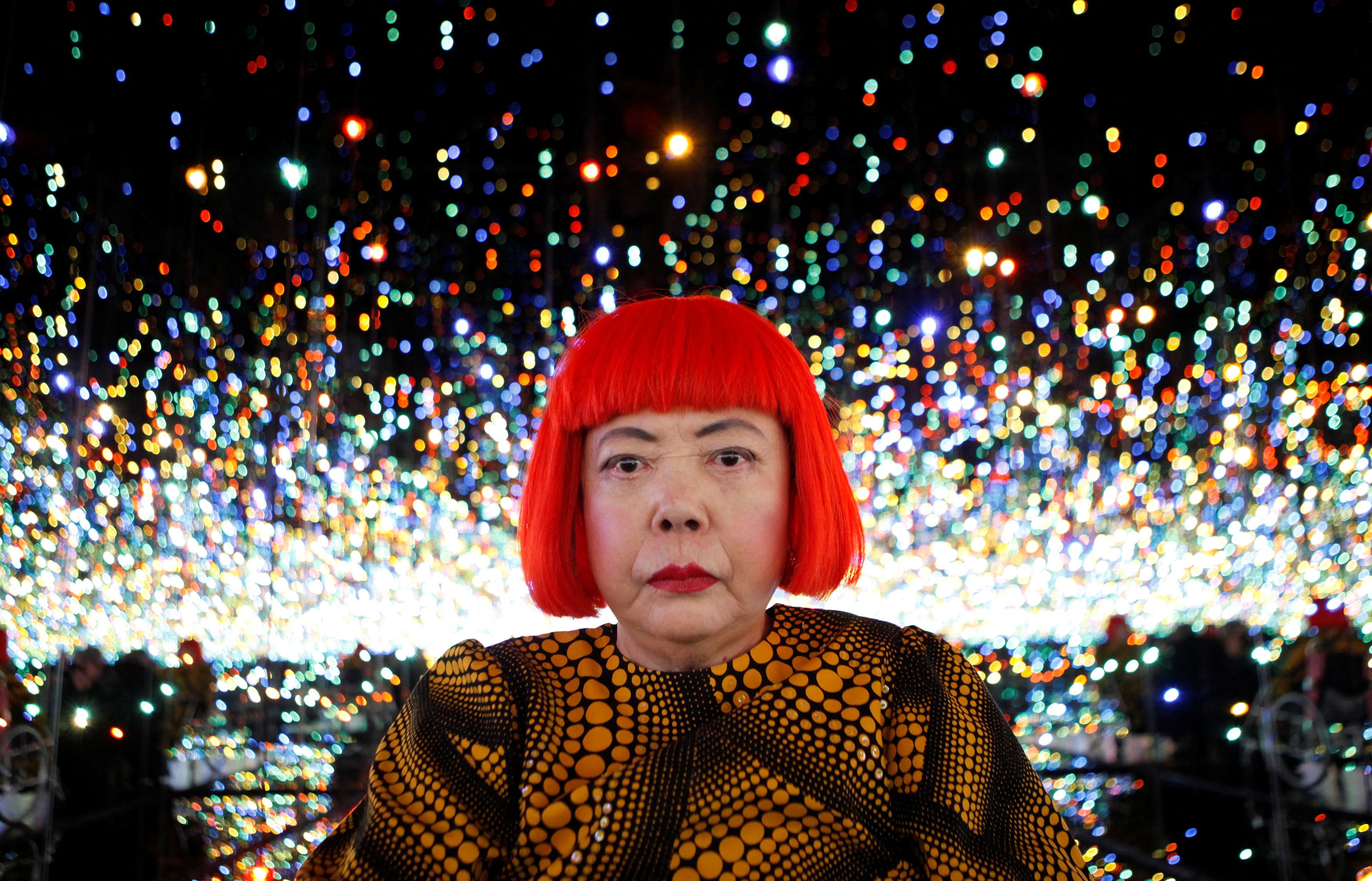 Japanese artist Yayoi Kusama poses for a photograph inside her Infinity Mirrored Room installation titled "The Souls of Millions of Light Years Away" during a media preview of her new exhibition at the David Zwirner gallery in New York November 7, 2013.