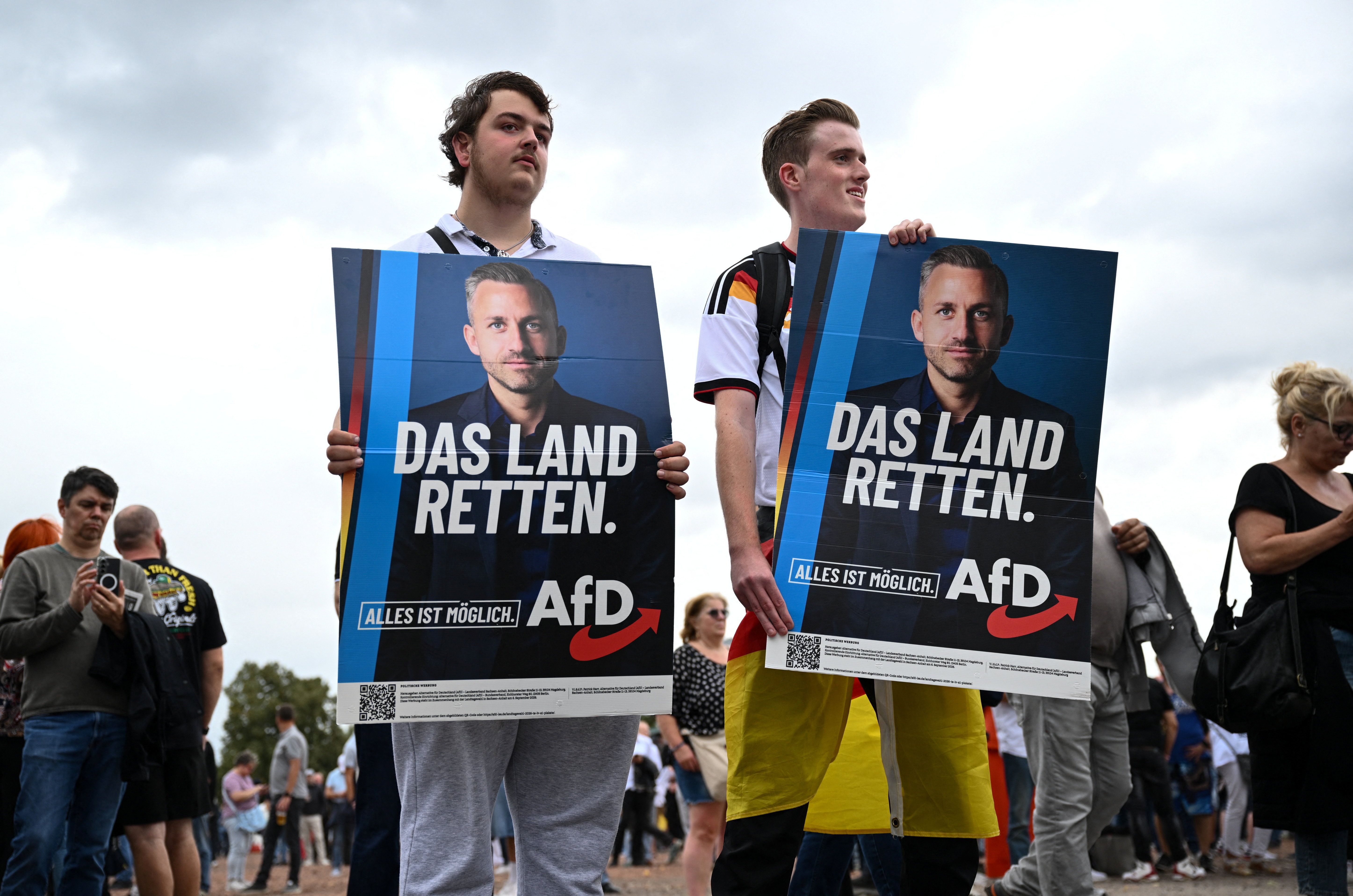 AfD supporters hold placards as they attend top candidate Ulrich Siegmund's campaign event in Magdeburg, Germany, on Friday.